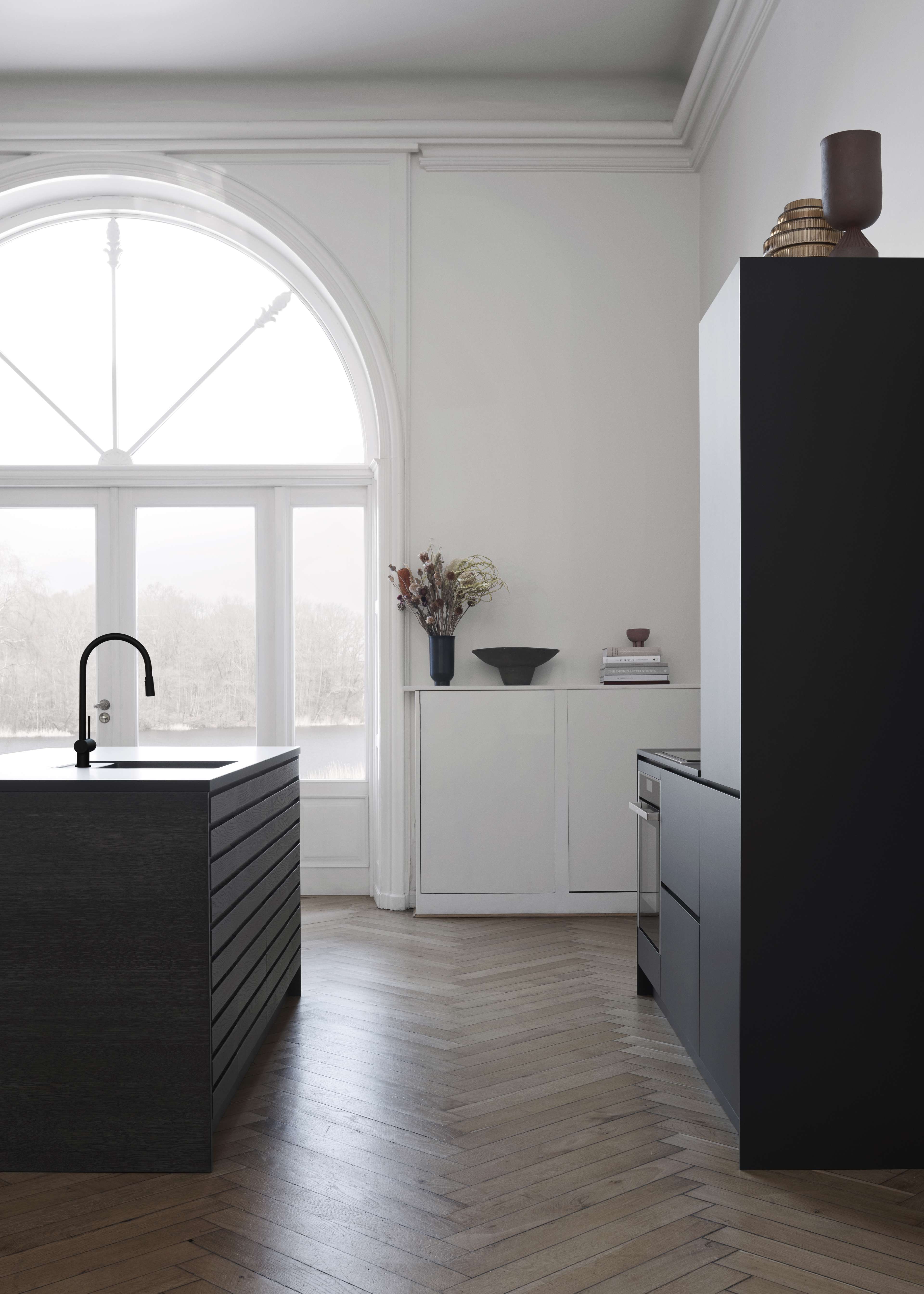 CIMA-Küche aus dunkler Eiche mit eleganten, minimalistischen Schränken, eleganten Linien und einer raffinierten Holzstruktur, die ein modernes Innendesign ergänzt.