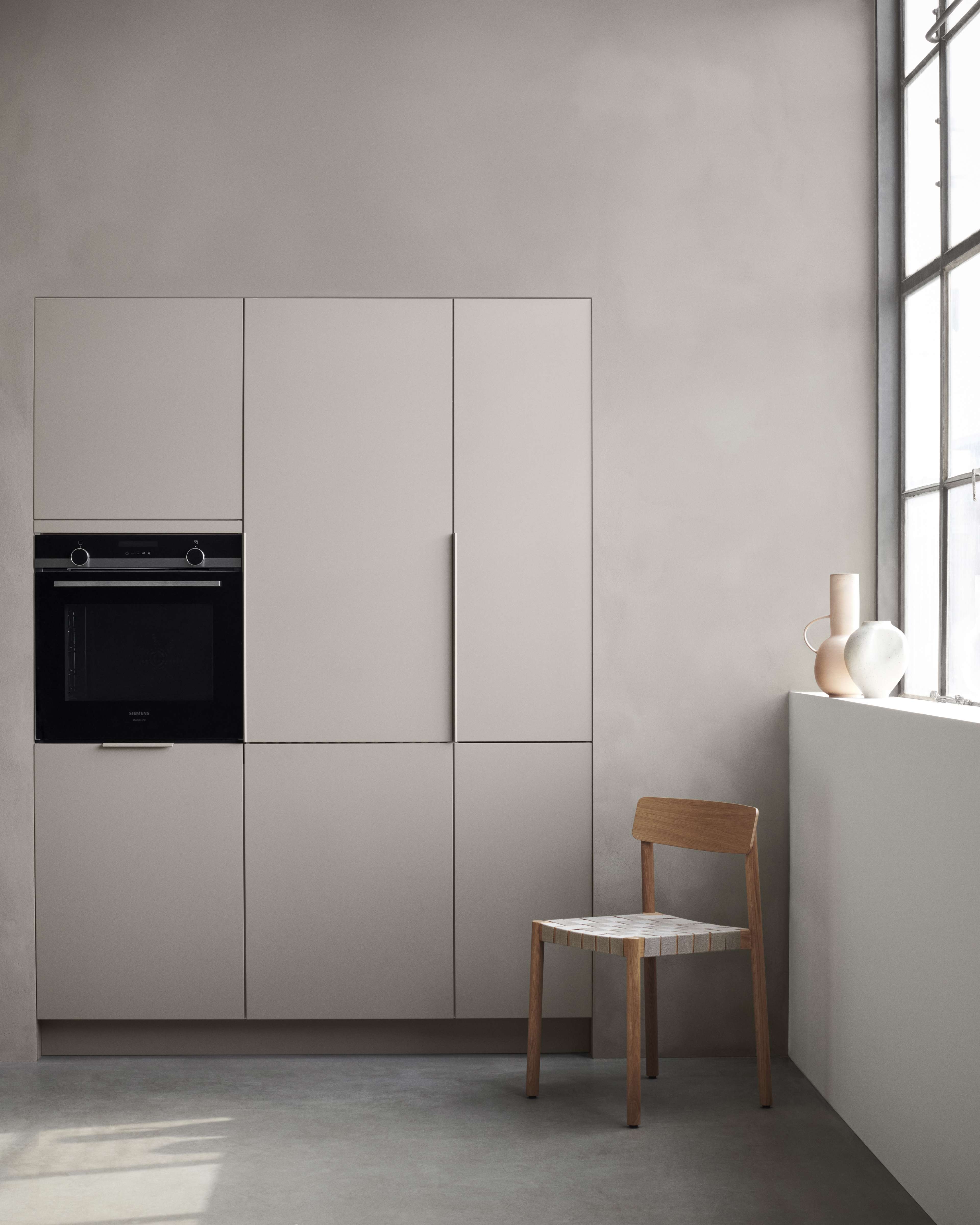 BORDO clay-Küchenschrank mit schlankem, minimalistischem Design, sanfter tonfarbener Oberfläche und integriertem Backofen, der einen modernen und stilvollen Kochraum aufwertet.