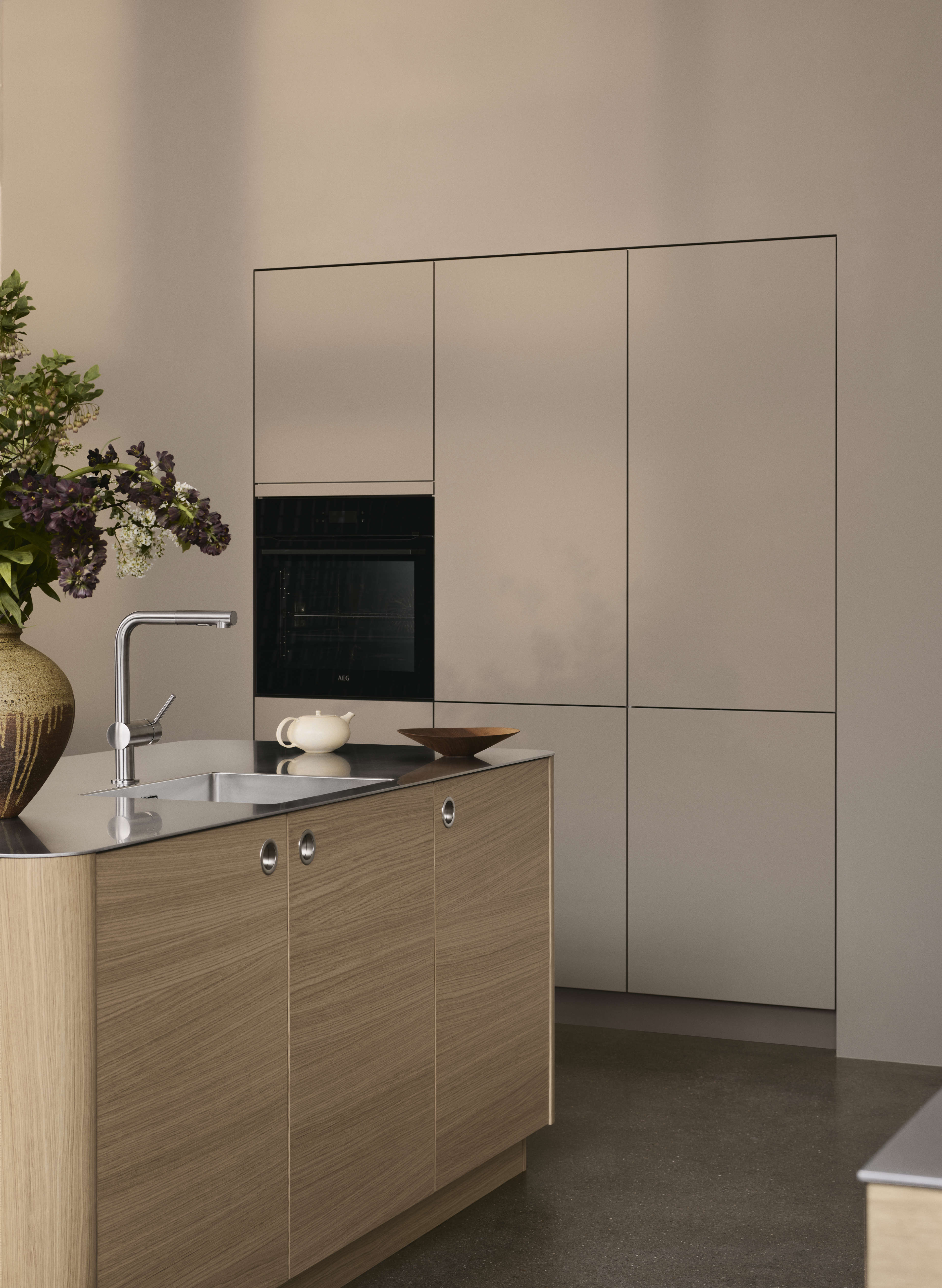 VEDA ljusa köksskåp i ek med minimalistisk design, med eleganta linjer och integrerade handtag, skapar ett sofistikerat och funktionellt utrymme.