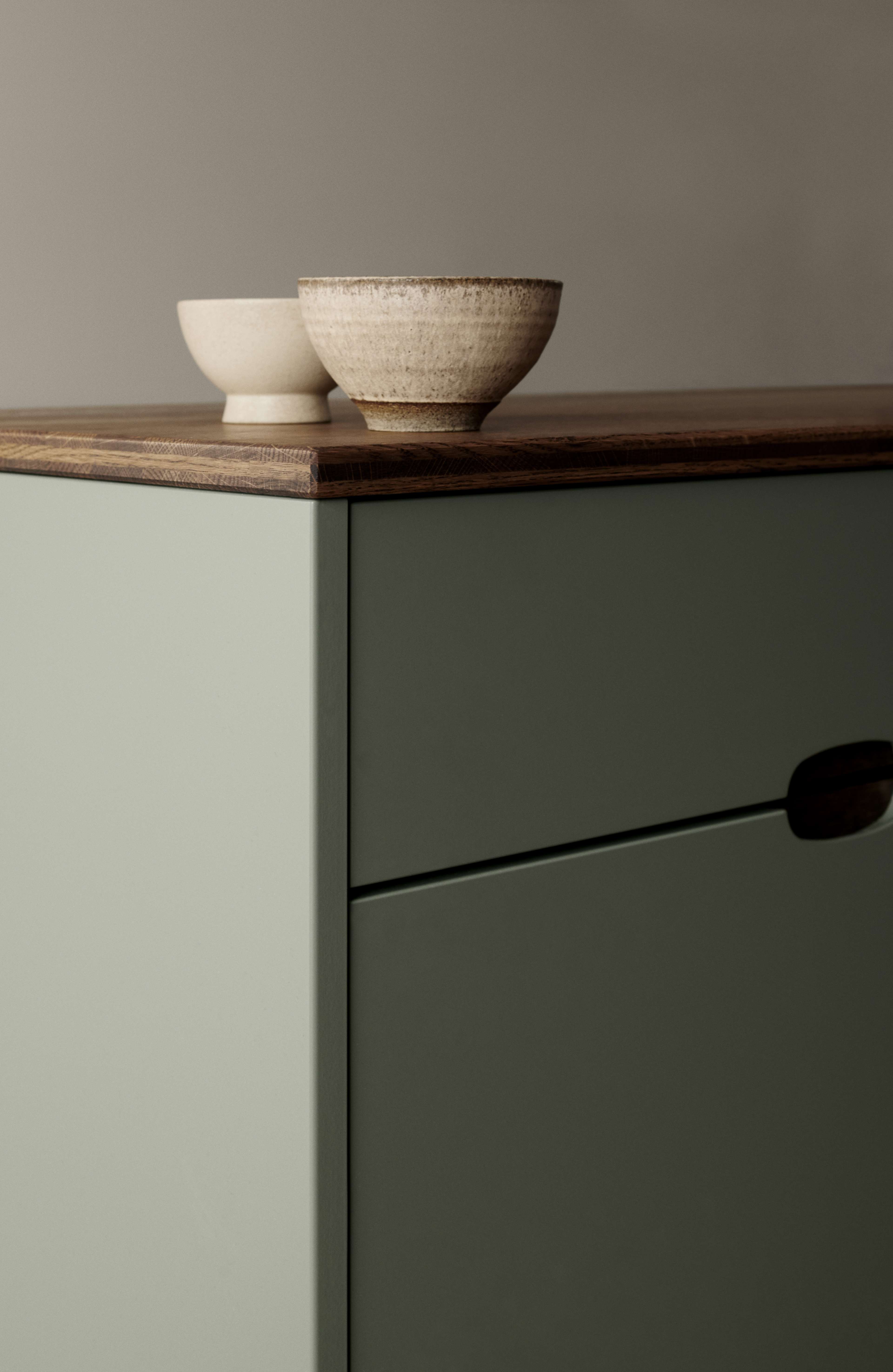 OMBRA grönt köksskåp med elegant, minimalistisk design med släta kanter och rik träbänkskiva för ett stilrent, modernt köksutrymme.