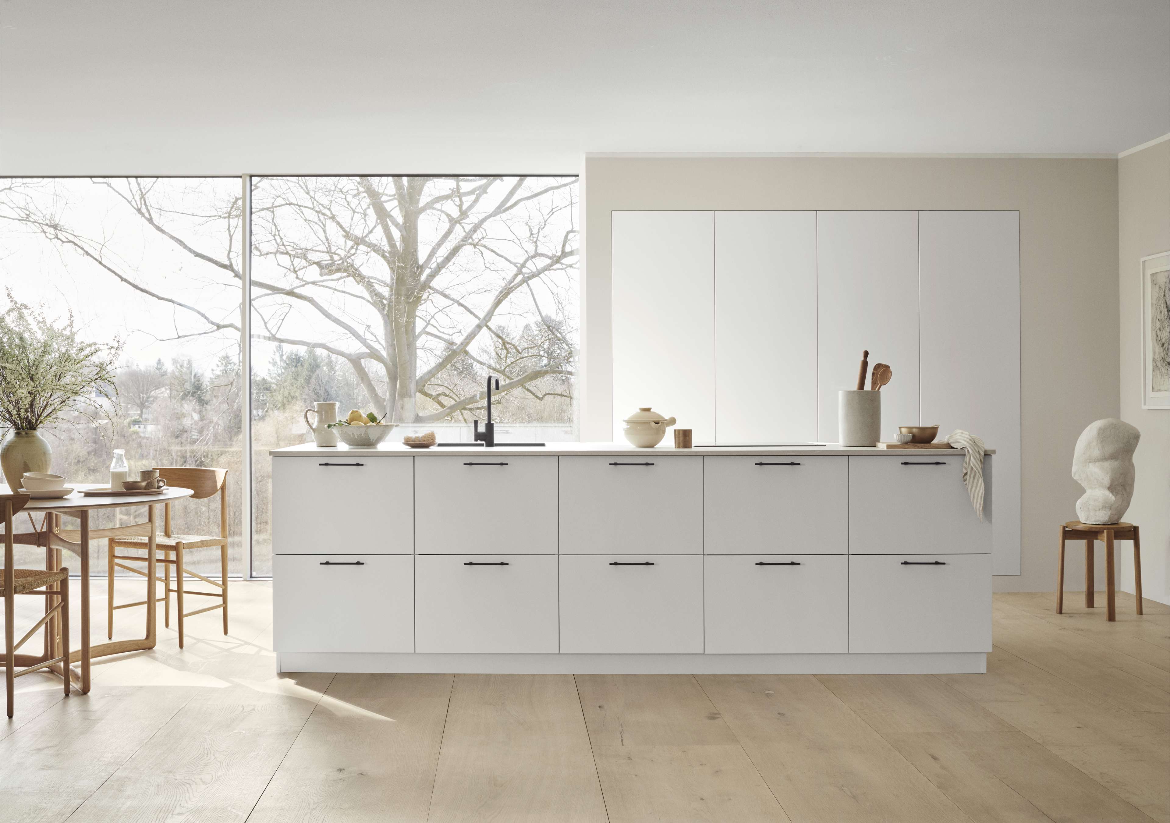 VEDA white kitchen with sleek cabinetry and minimalist design, featuring smooth surfaces and integrated handles for a modern, Scandinavian look.