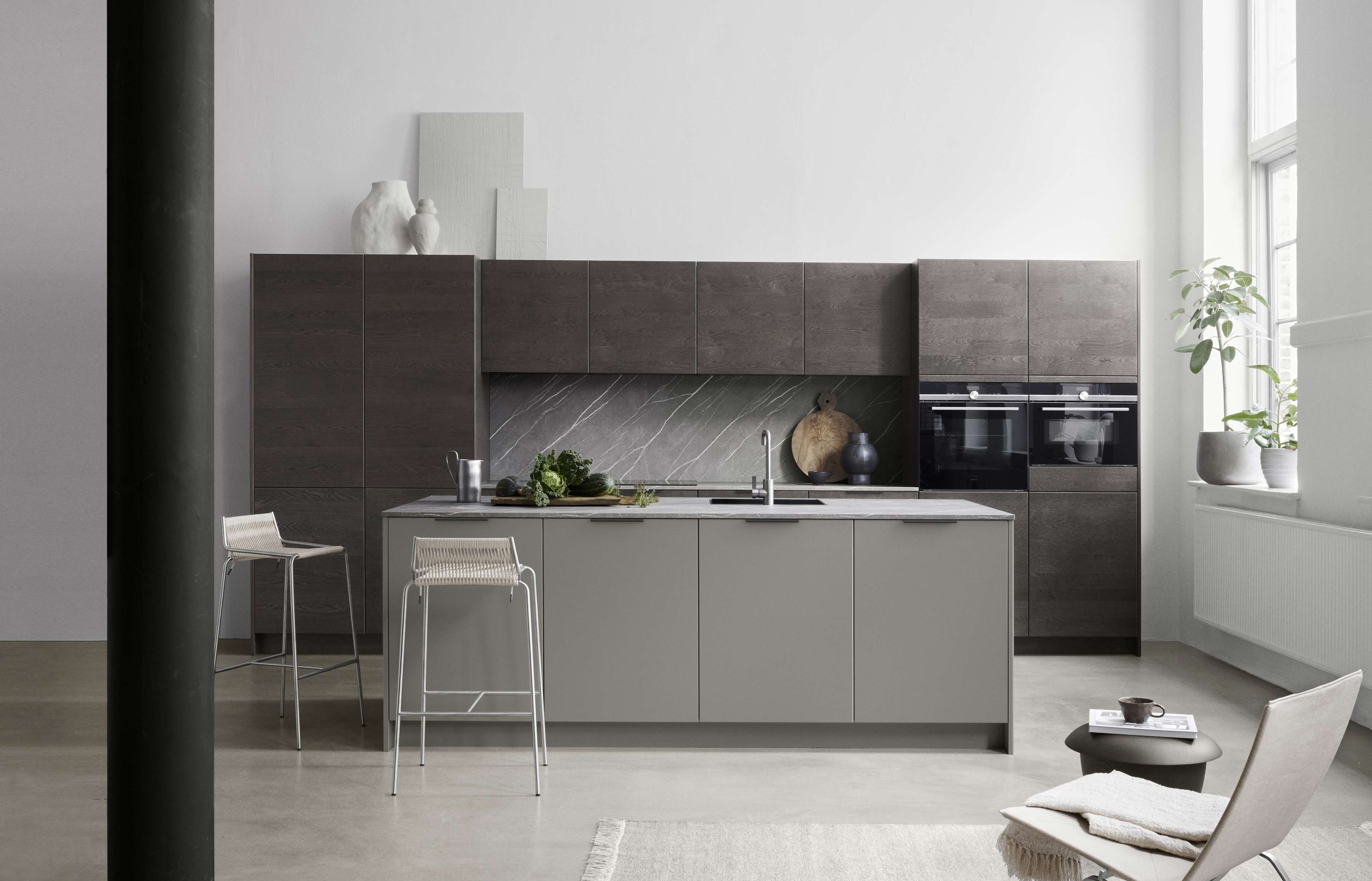 Die graue Küche von BORDO London verfügt über elegante, minimalistische Schränke, elegante Arbeitsplatten und moderne Geräte, die einen anspruchsvollen kulinarischen Raum schaffen.