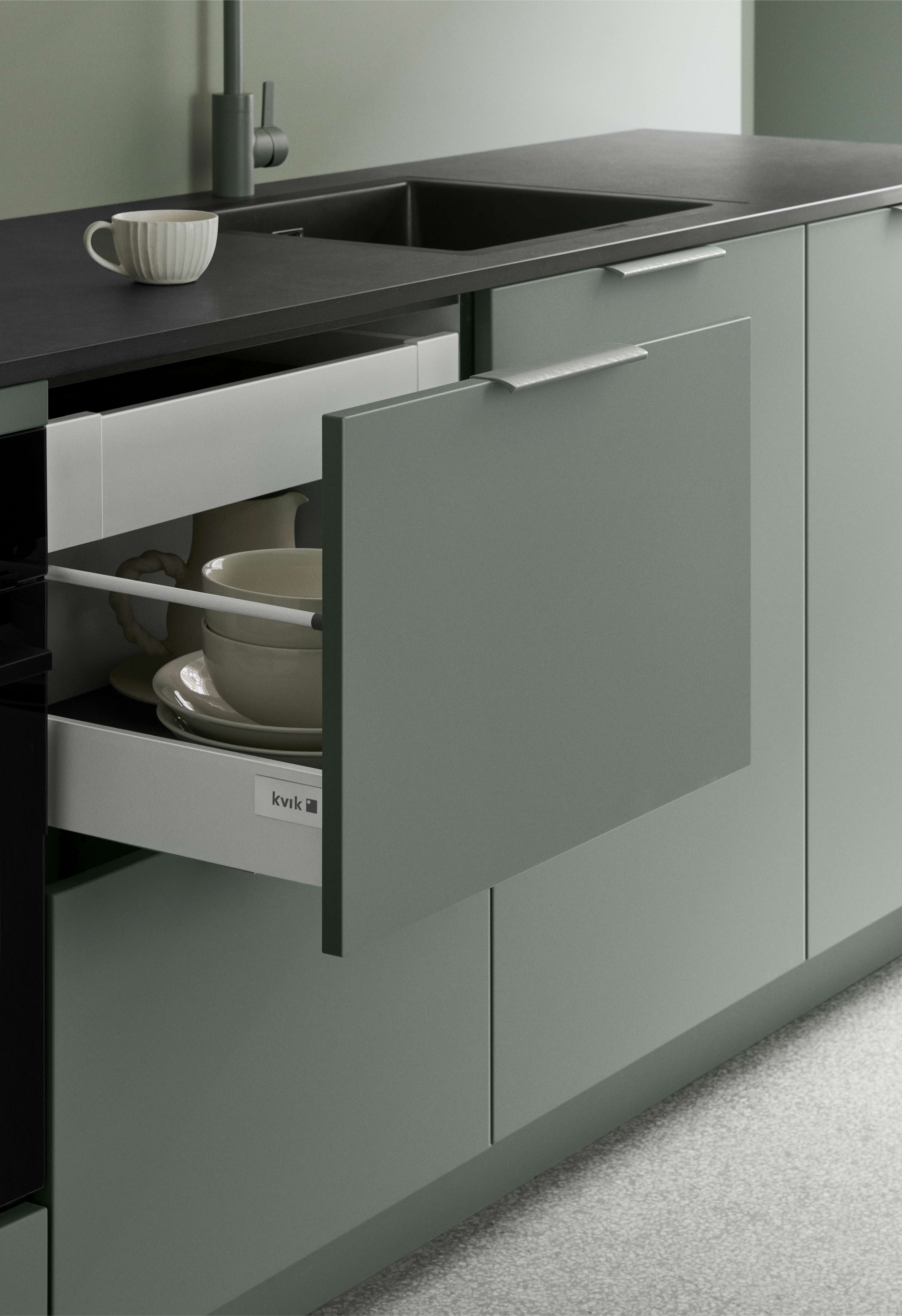 Cuisine verte VEDA avec armoires élégantes et modernes et finition mate. Doté de poignées intégrées et d'un grand espace de rangement, offrant un look frais et minimaliste.