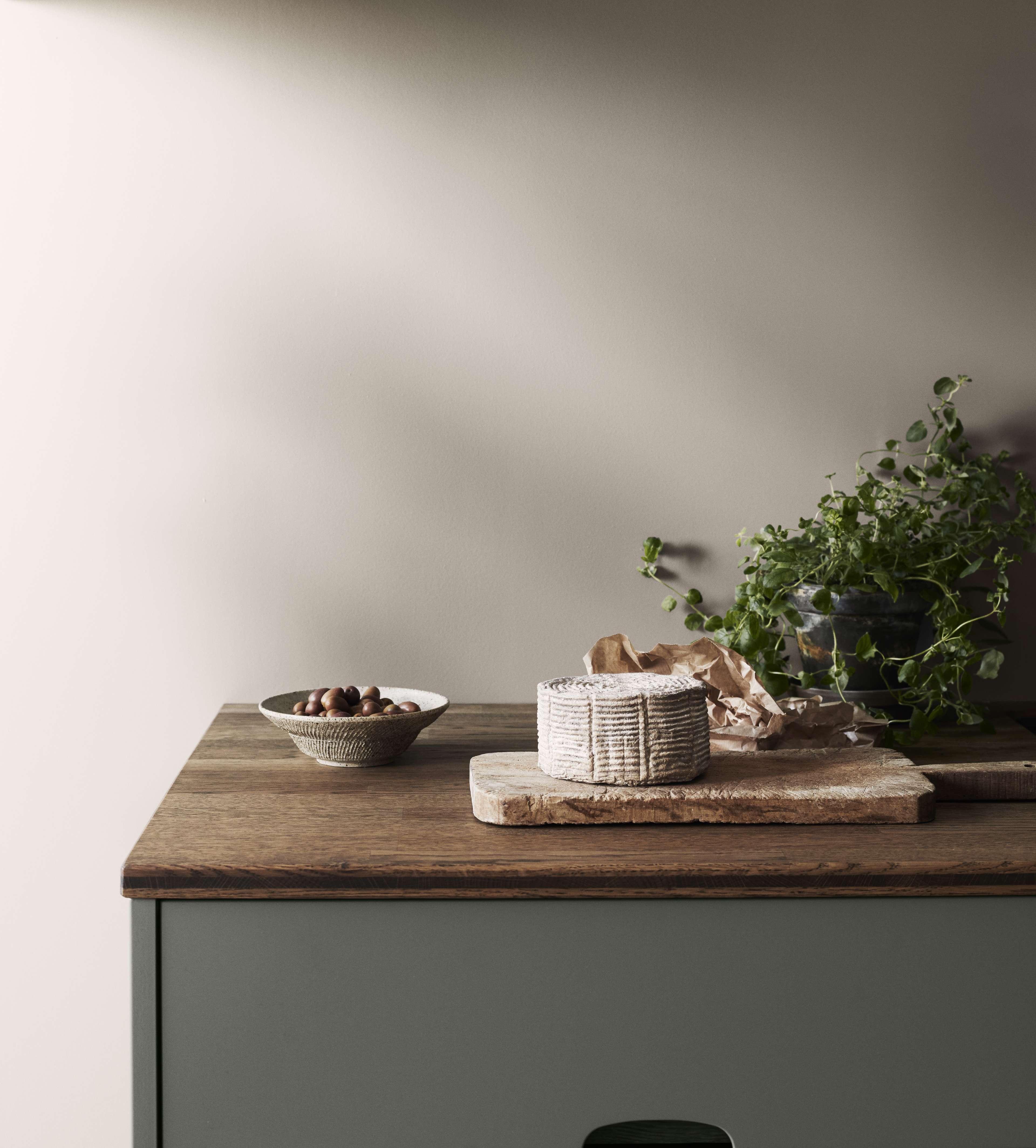 Green kitchen with focus on a wooden worktop