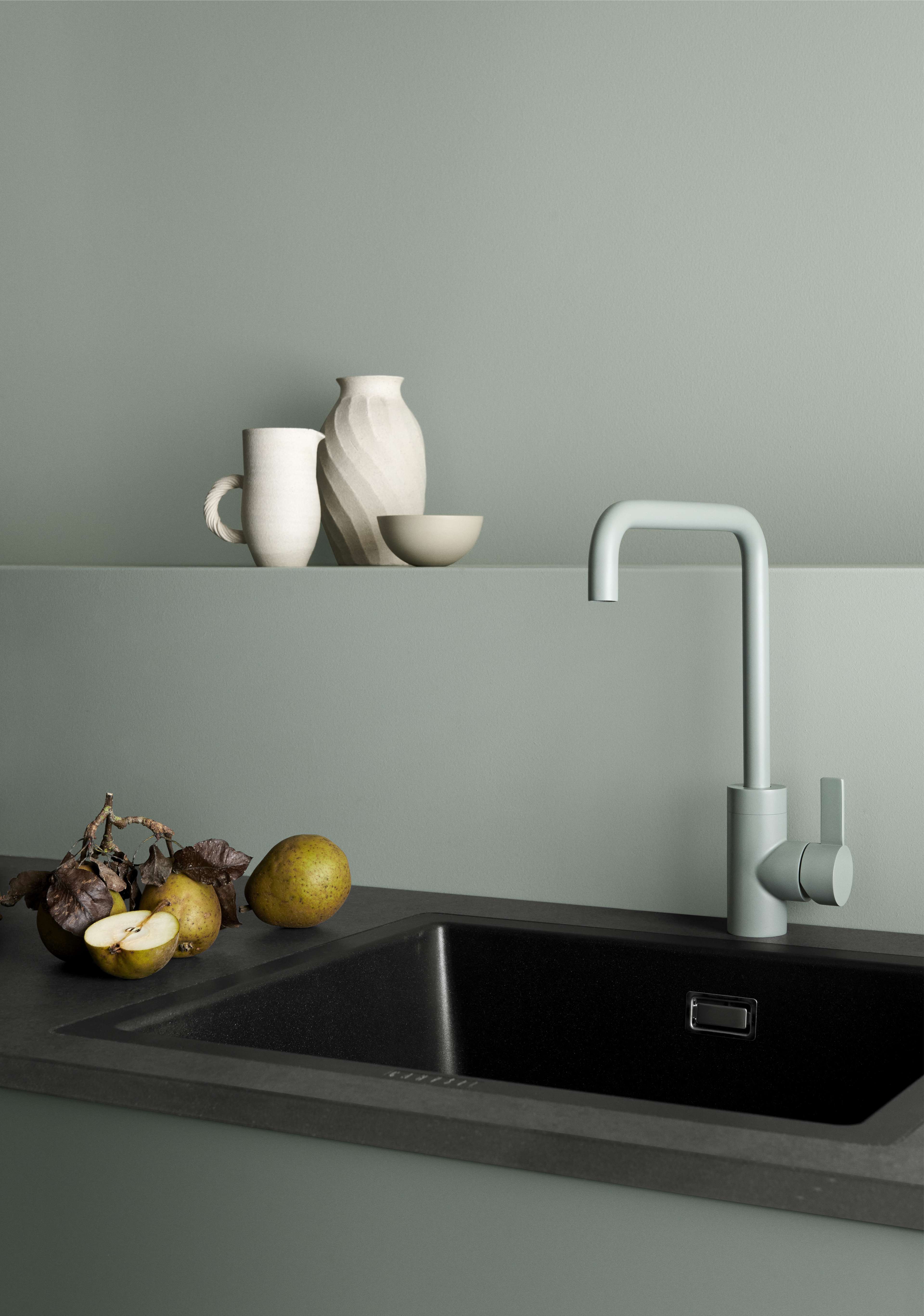 VEDA Touch green kitchen with minimalist design, featuring a sleek faucet and modern sink, creating an elegant Nordic-inspired cooking space.