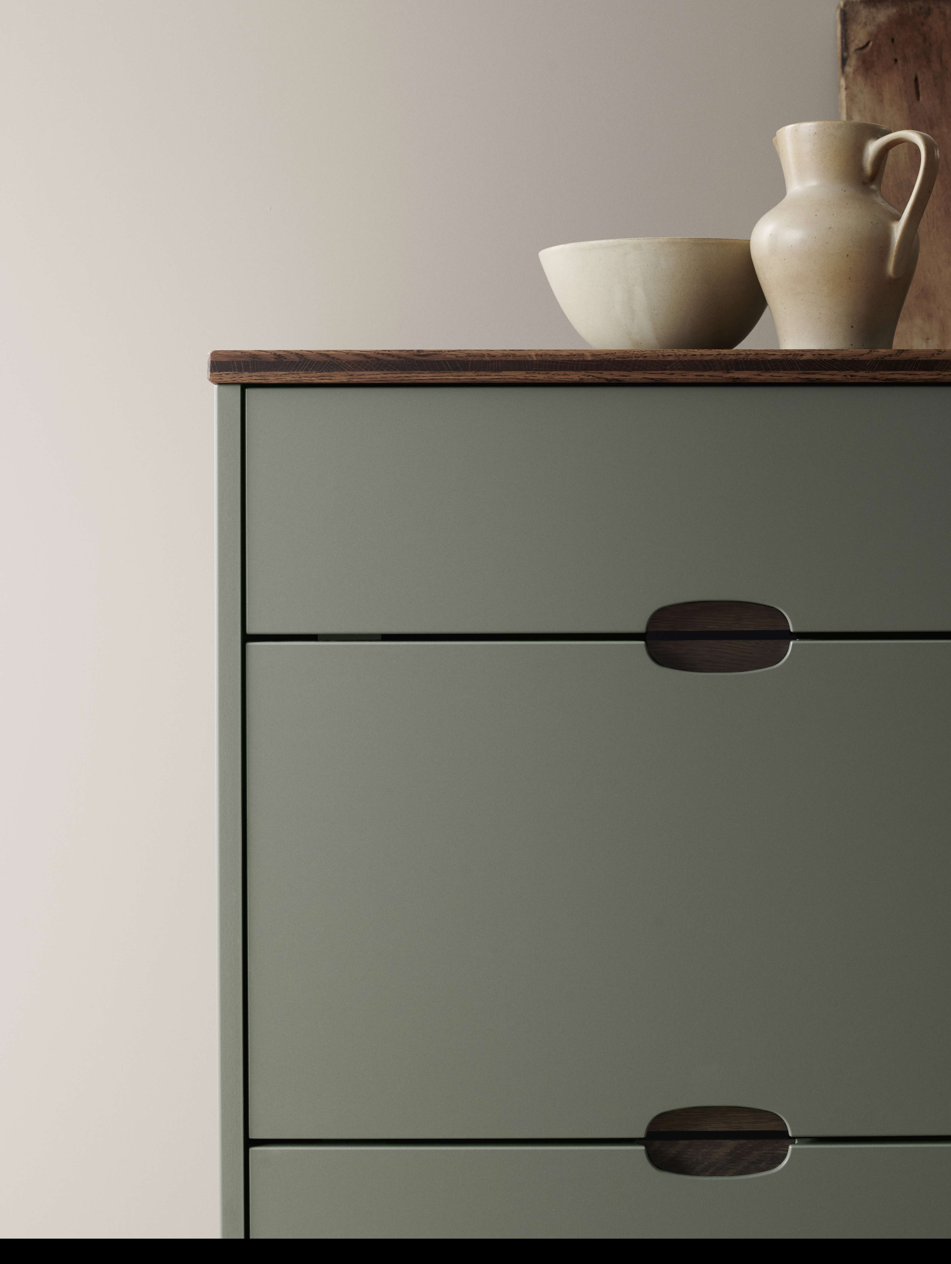 Green kitchen with integrated handles and a wooden worktop