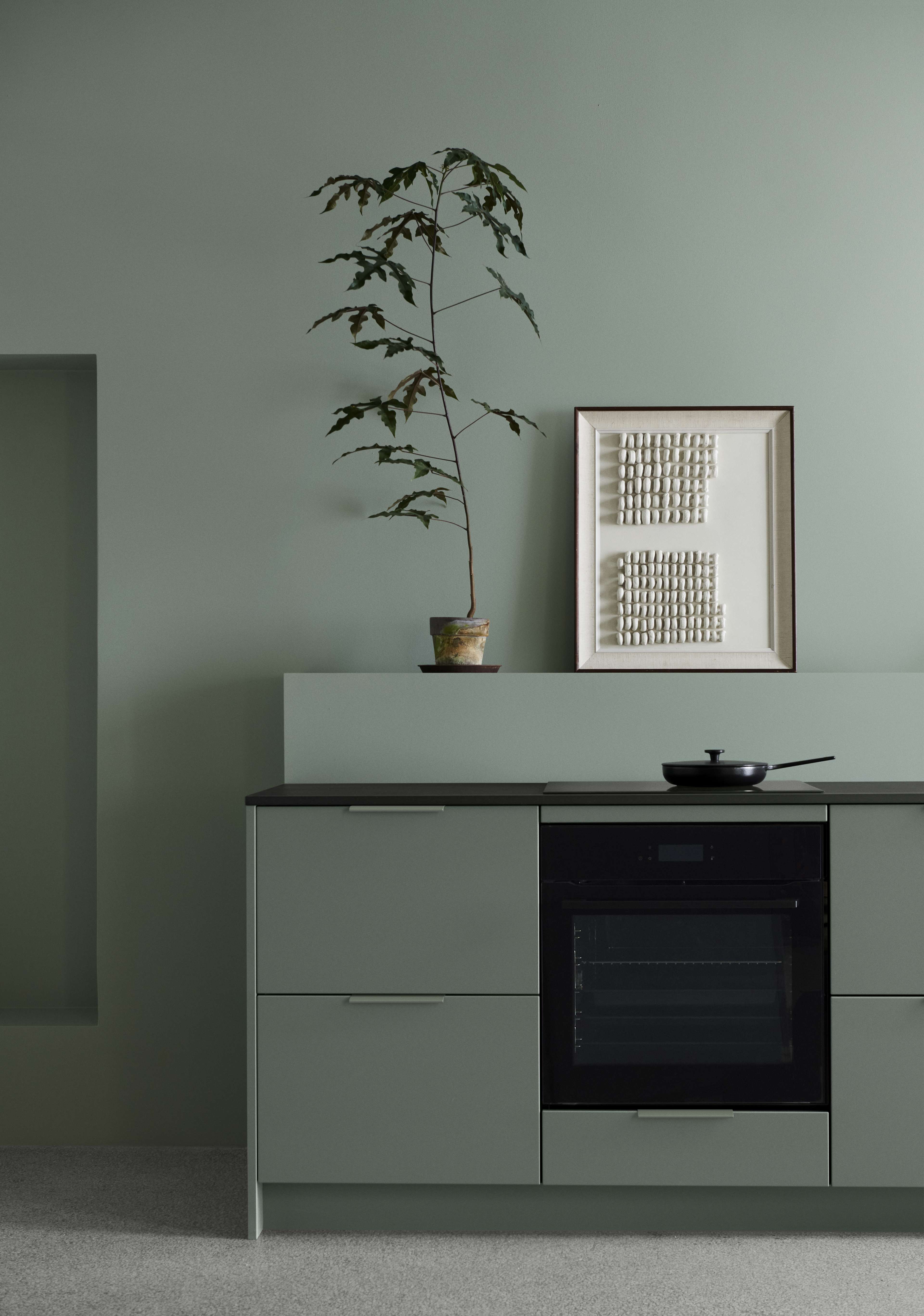 VEDA grønne køkkenskabe med slankt moderne design, med mat finish og integrerede hvidevarer, der skaber et sammenhængende og stilfuldt kulinarisk rum.