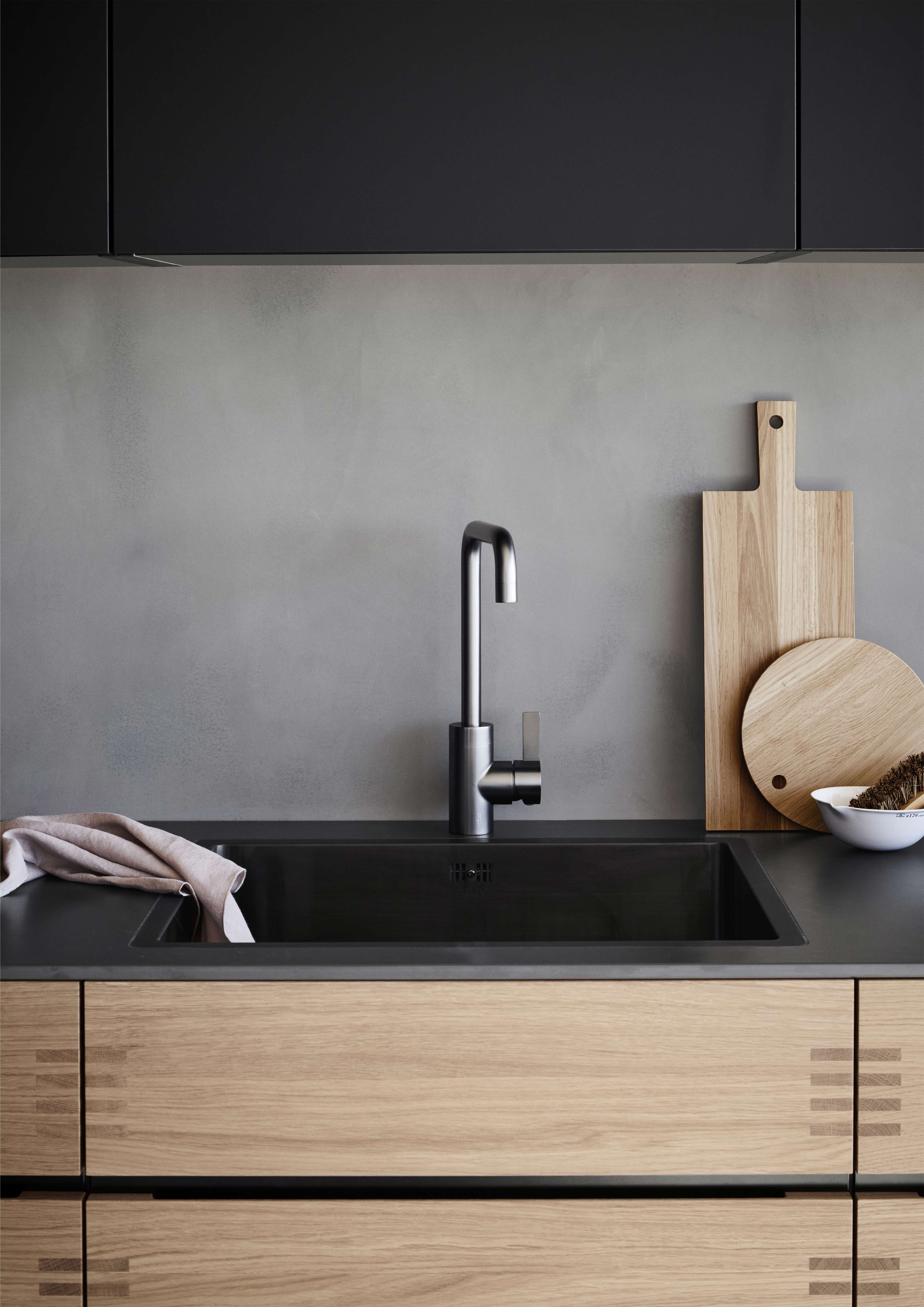 OAKWOOD träkök med snygga svarta bänkskivor och mattsvart kran, som visar upp modern stil med detaljer i naturliga träfibrer för en varm estetik.