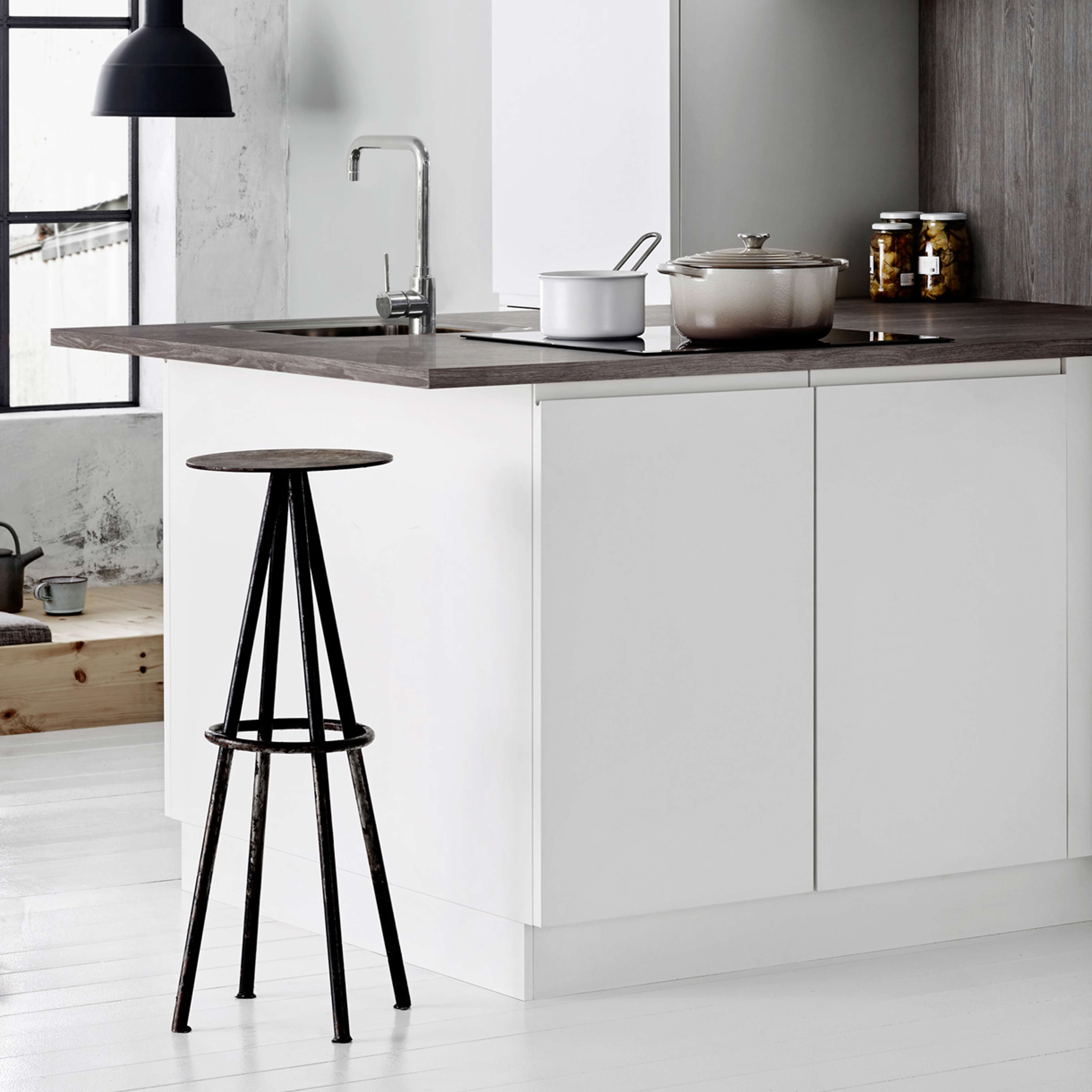 NOLIAM white kitchen cabinetry with sleek handles, wood countertop, and integrated sink, embodying minimalist design for modern homes.