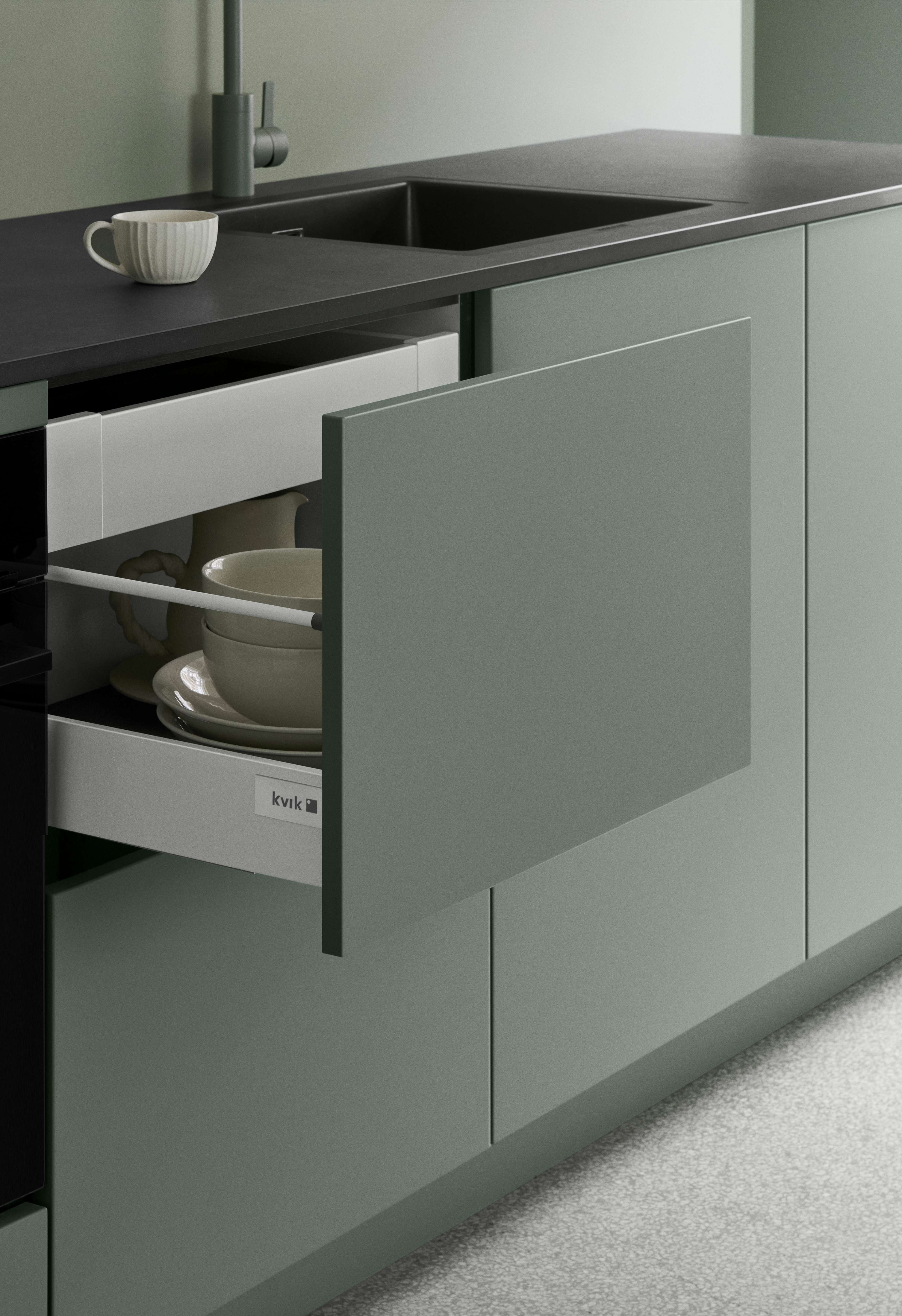 VEDA Touch-grønt køkken byder på elegant opbevaring med minimalistisk design, mat finish og glatte overflader, der afspejler moderne elegance og stil.