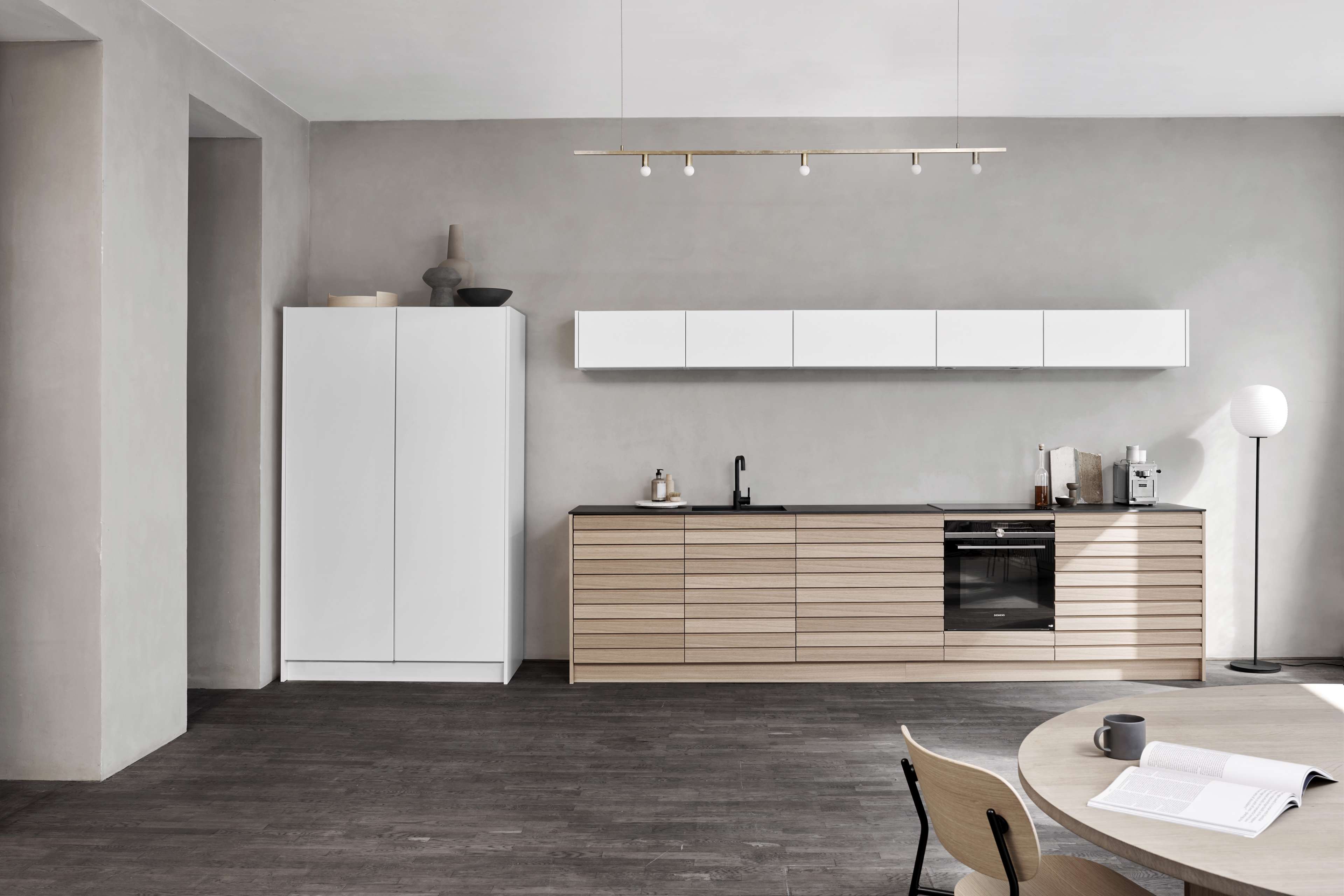 CIMA-Küchenschränke aus heller Eiche mit schlanken horizontalen Linien und minimalistischem Design bieten einen modernen und funktionalen Kochbereich mit nordischer Eleganz.