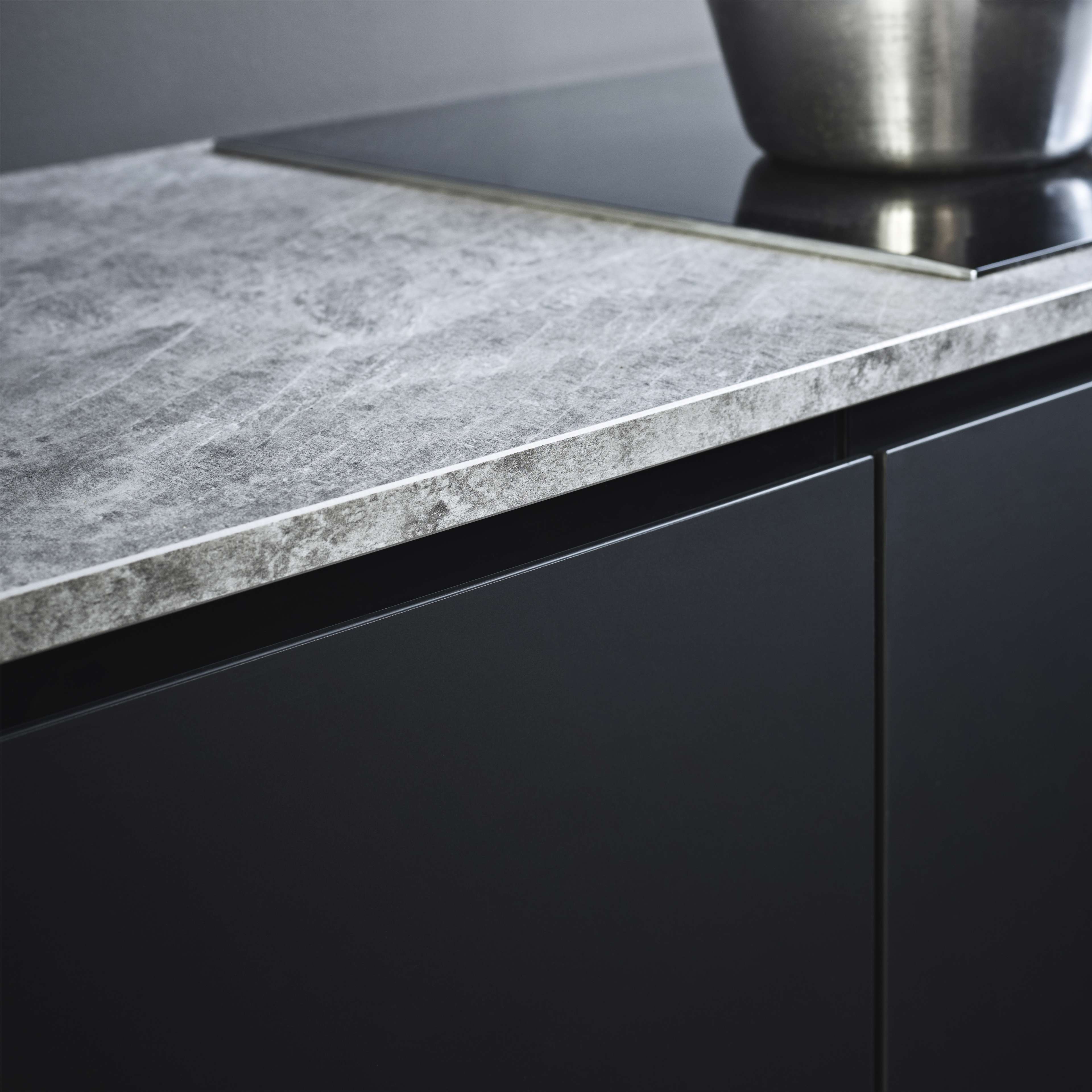 PRATO black kitchen features sleek cabinets with a modern matte finish, complemented by a textured gray countertop for a contemporary look.