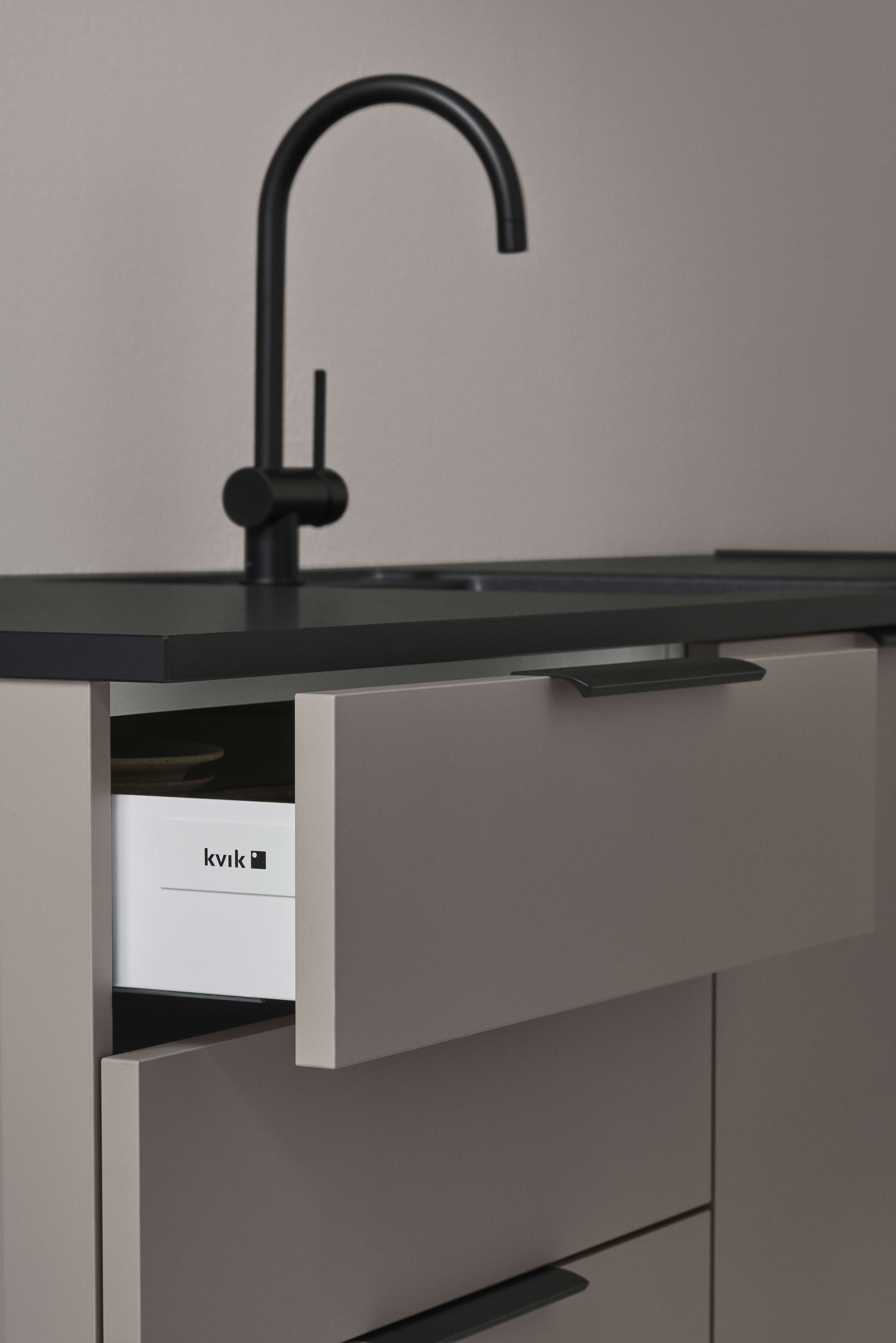 Armoire beige BORDO Arizona avec comptoir noir élégant, doté de poignées minimalistes et de solutions de rangement intégrées pour un look de cuisine moderne.