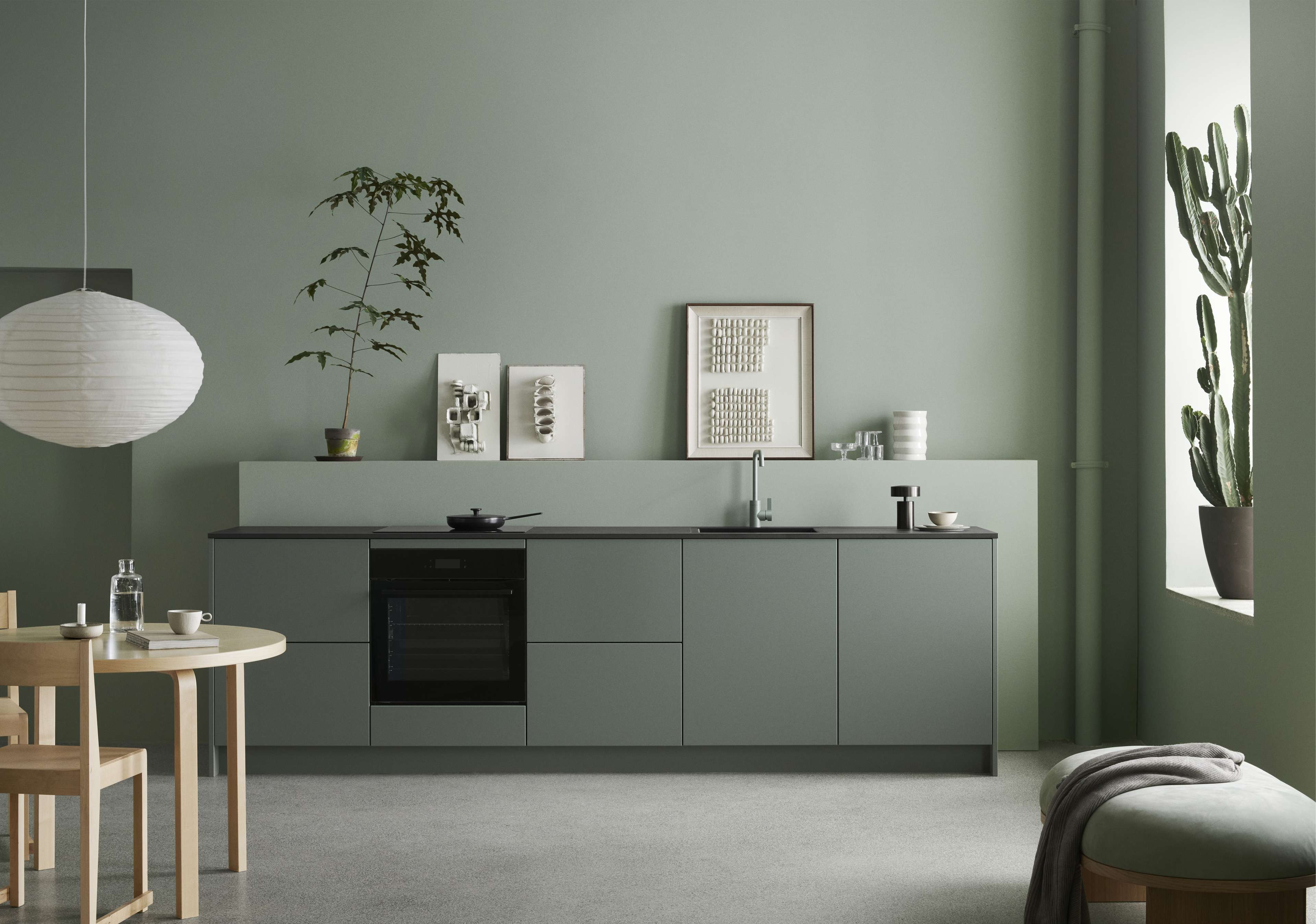 VEDA Touch green kitchen cabinets with minimalist design, matte finish, creating a calm and modern Nordic style ambiance in the kitchen space.