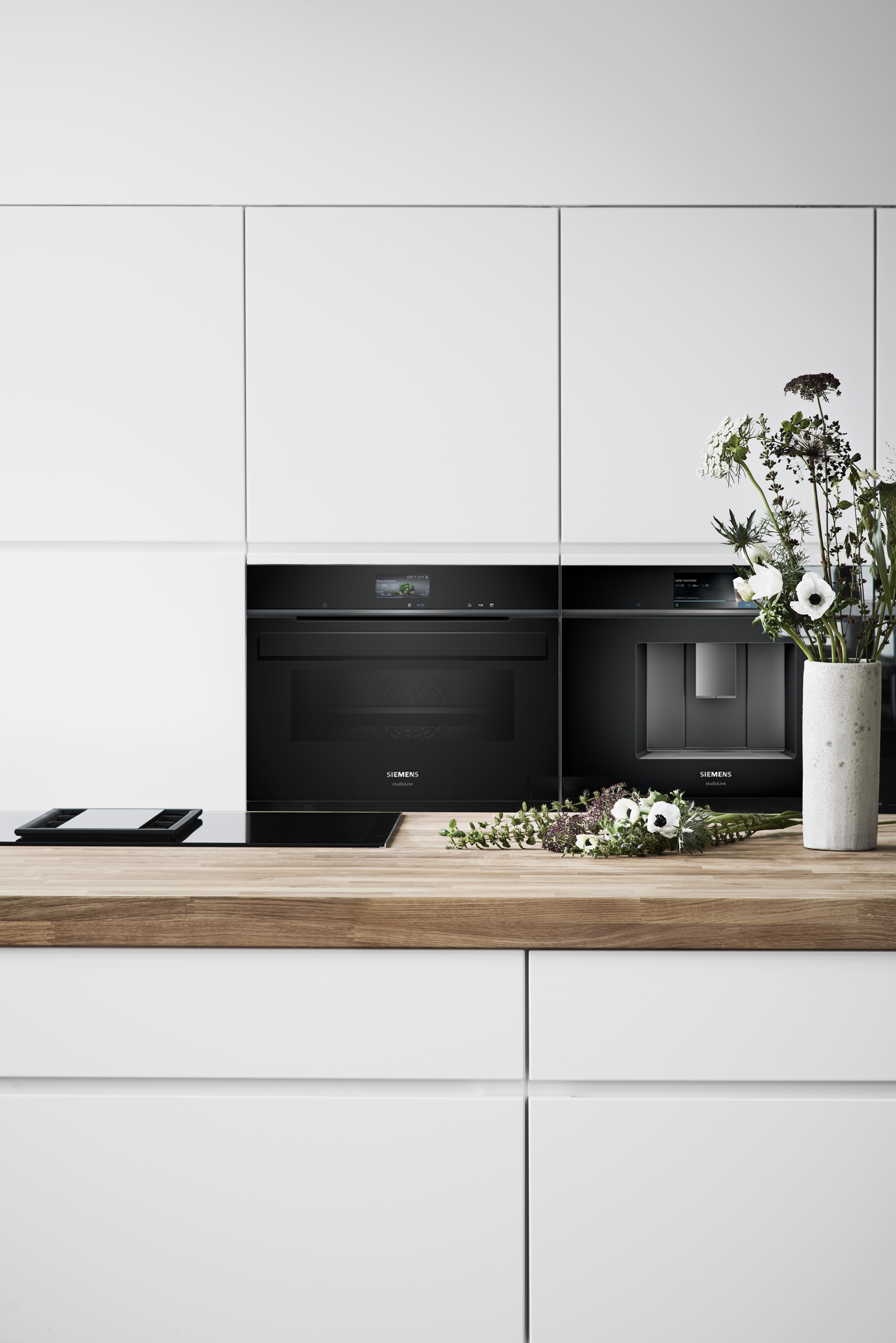 White kitchen with a kitchen island and a solid wood worktop
