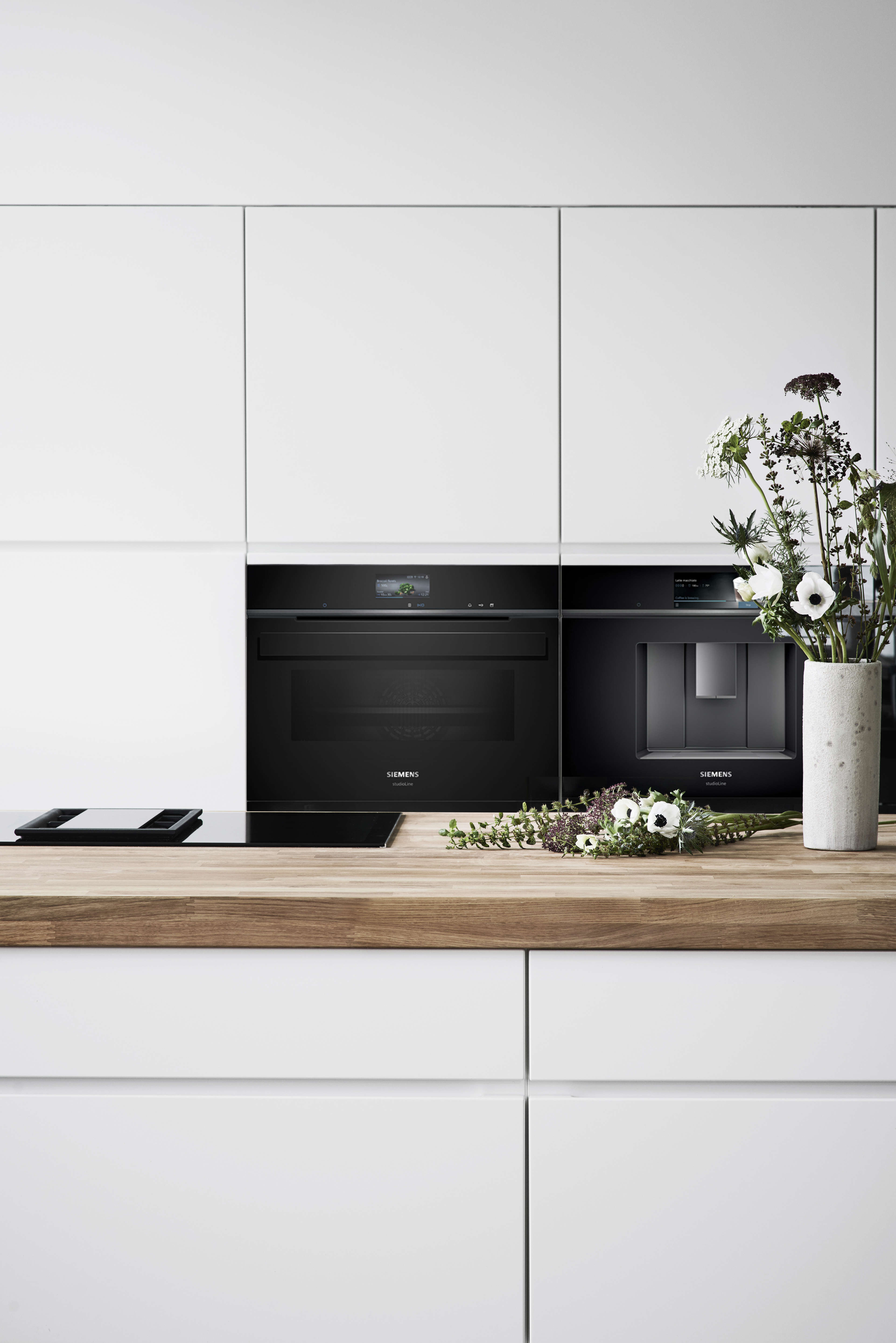Witte keuken met een massief houten werkblad en ingebouwde huishoudelijke apparaten