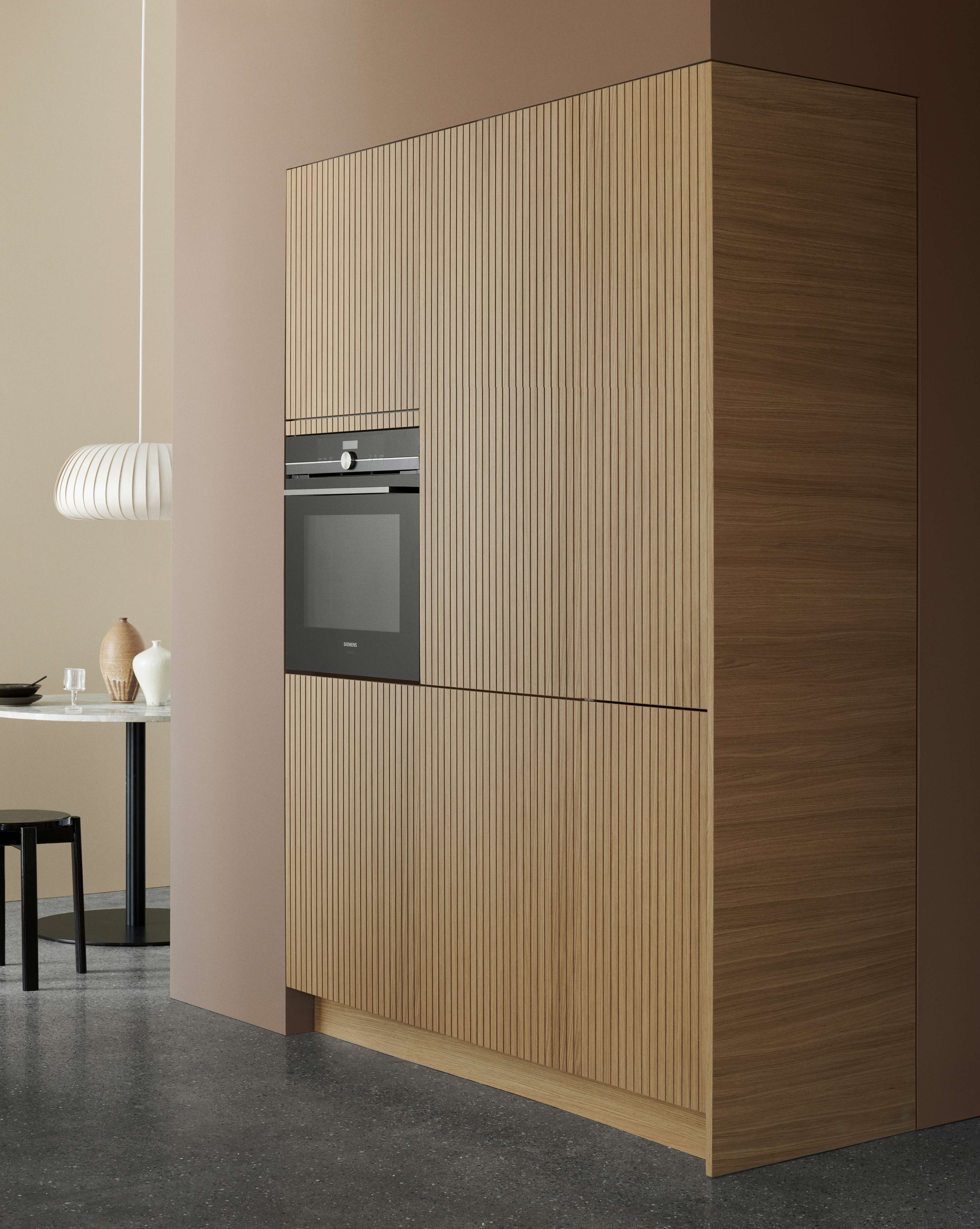 CORISA light oak kitchen cabinetry with sleek vertical slats, modern integrated oven, and minimalist Scandinavian design for a stylish, organized space.