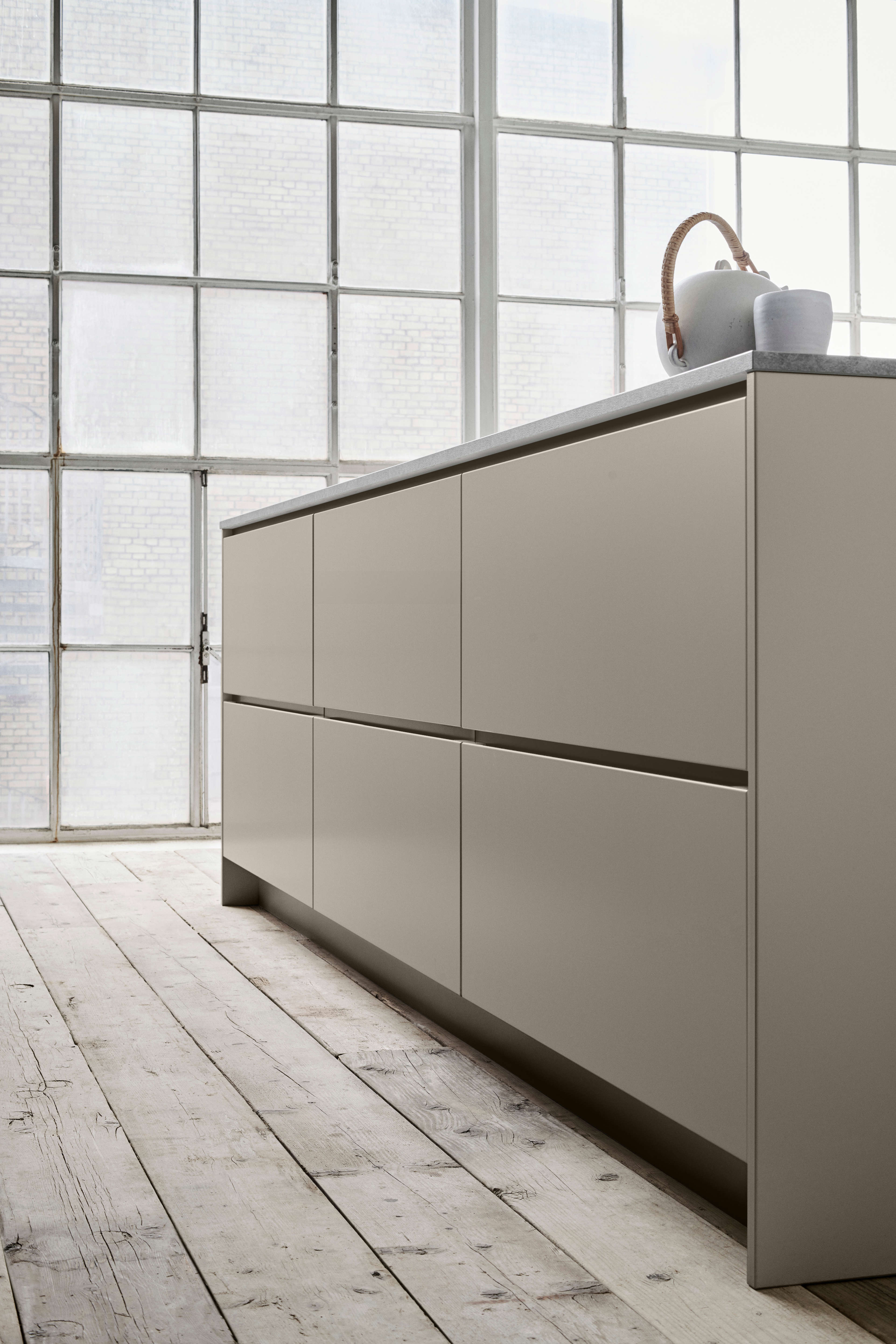 MANO arizona beige köksskåp som visar upp minimalistisk design med sömlösa ytor, som betonar modern elegans och funktionalitet.