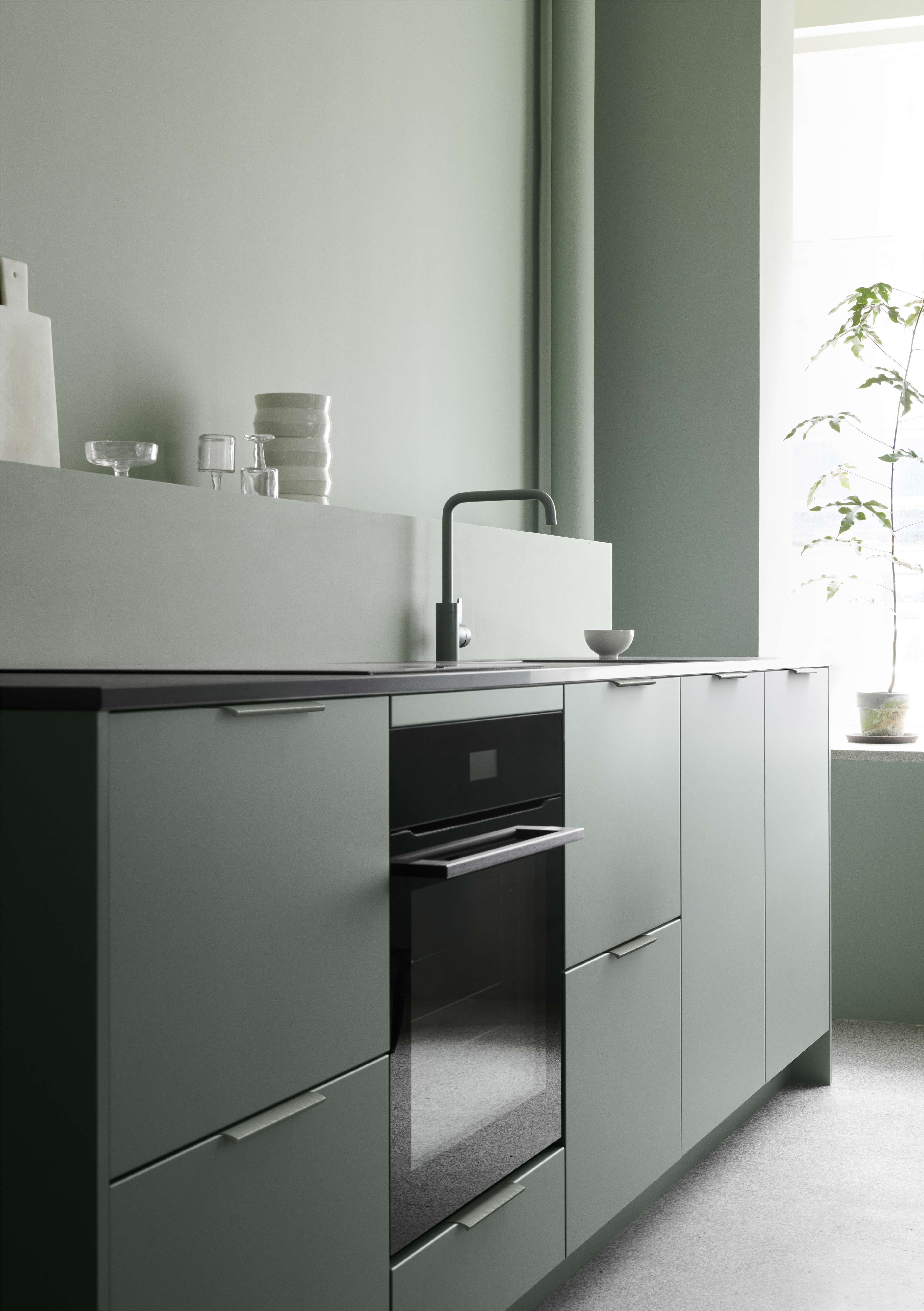 VEDA green kitchen cabinets with matte finish, sleek handle design, creating a serene modern style. Light accents complement the cohesive look.