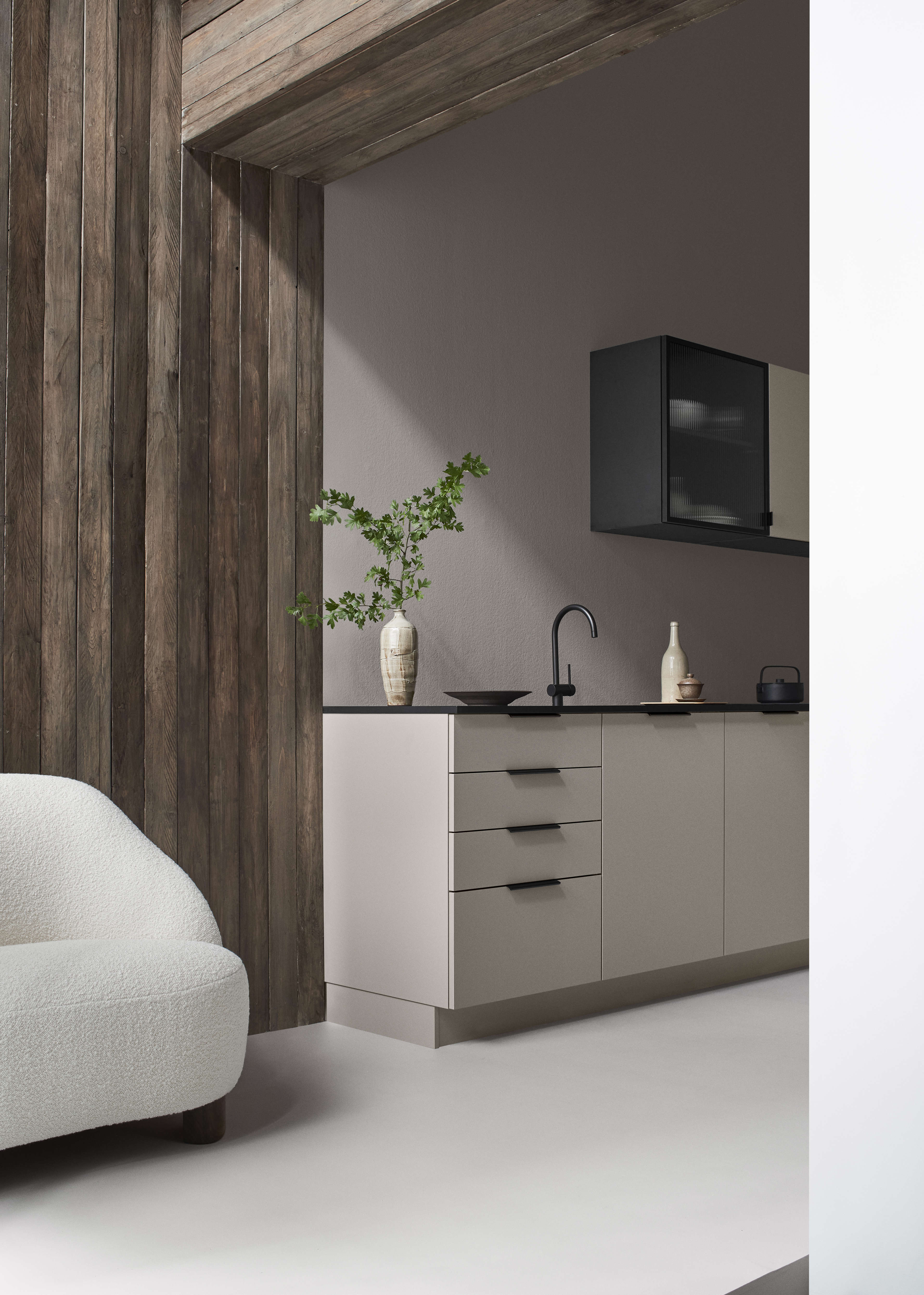 Die beige Küche von BORDO Arizona mit minimalistischem Design, eleganten Schränken und einer modernen schwarzen Arbeitsplatte schafft einen eleganten kulinarischen Raum.