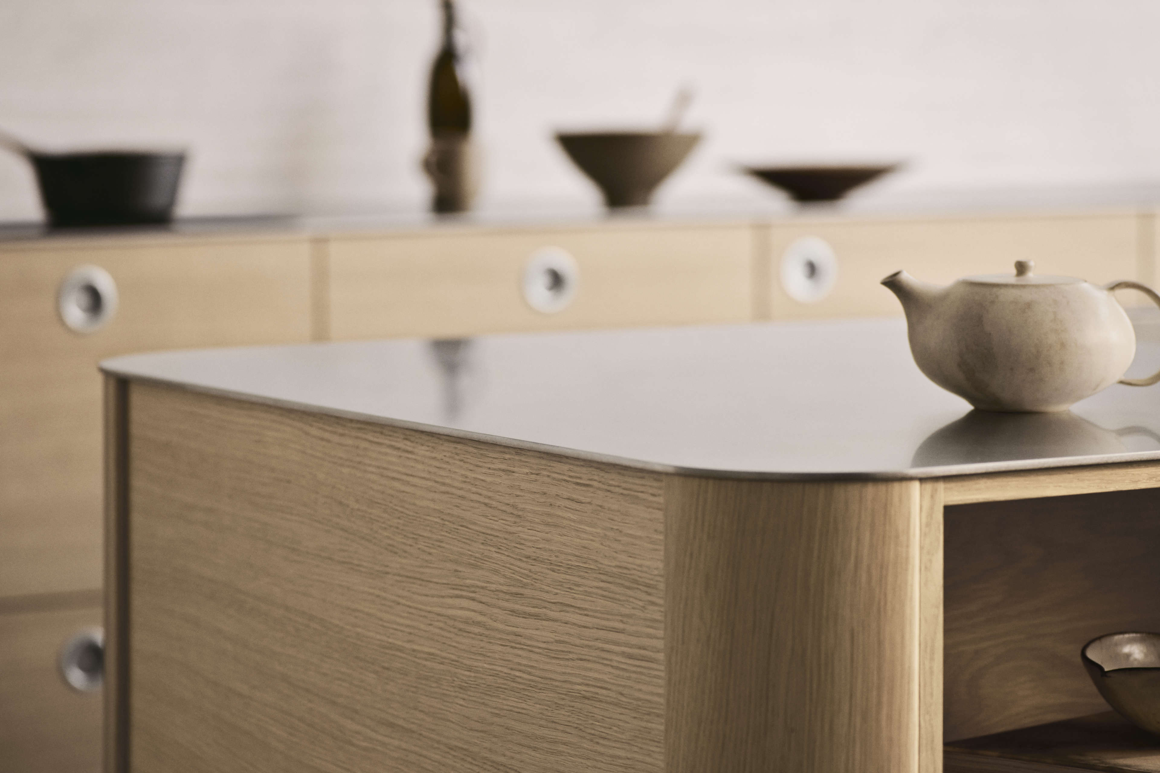 VEDA light oak kitchen island with smooth metal countertop, showcasing modern Scandinavian design with clean lines and warm, natural wood tones.