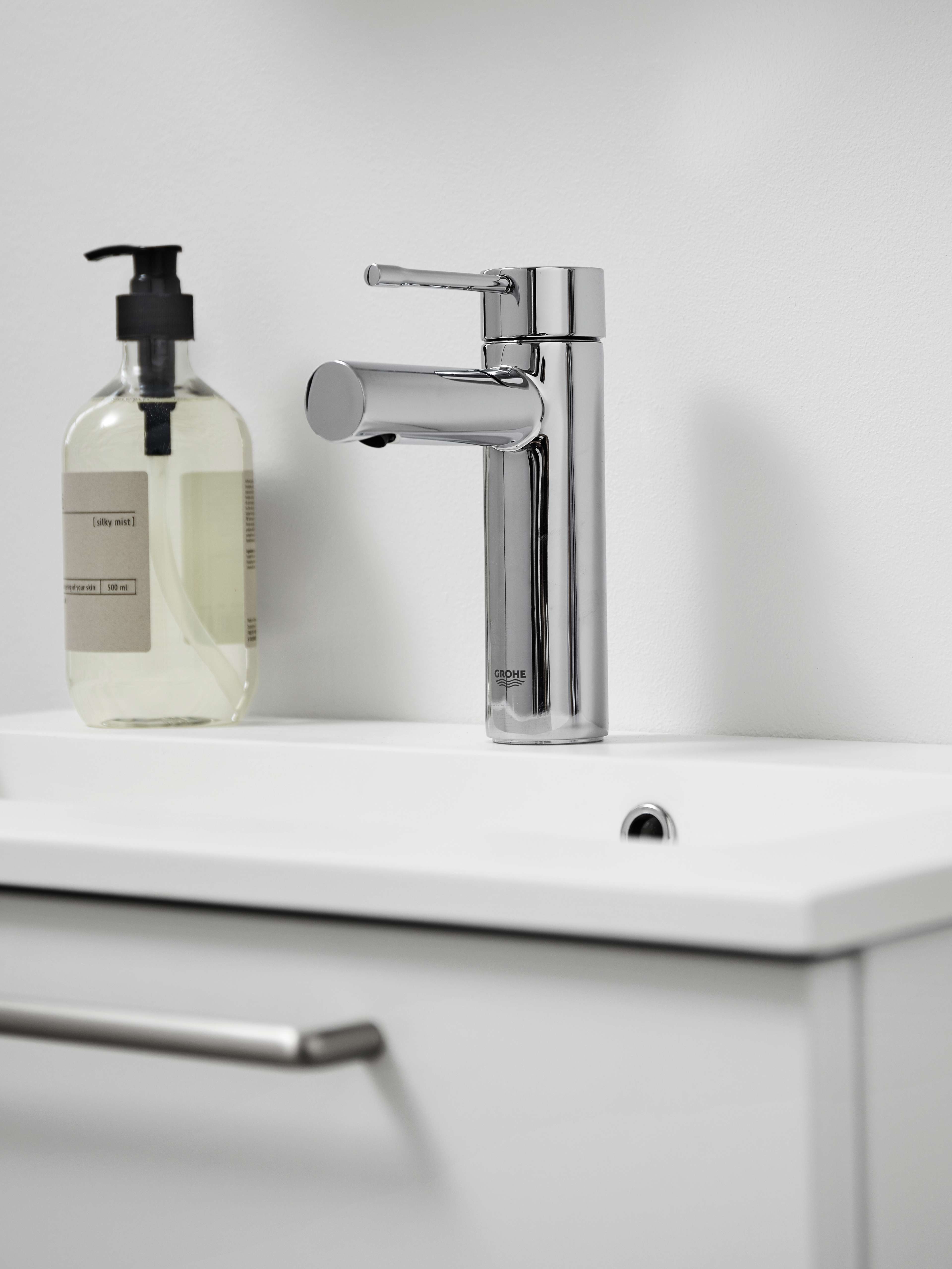 VEDA white bathroom sink with sleek chrome faucet, offering a minimalist and clean design for modern bath spaces, enhancing any bathroom decor.