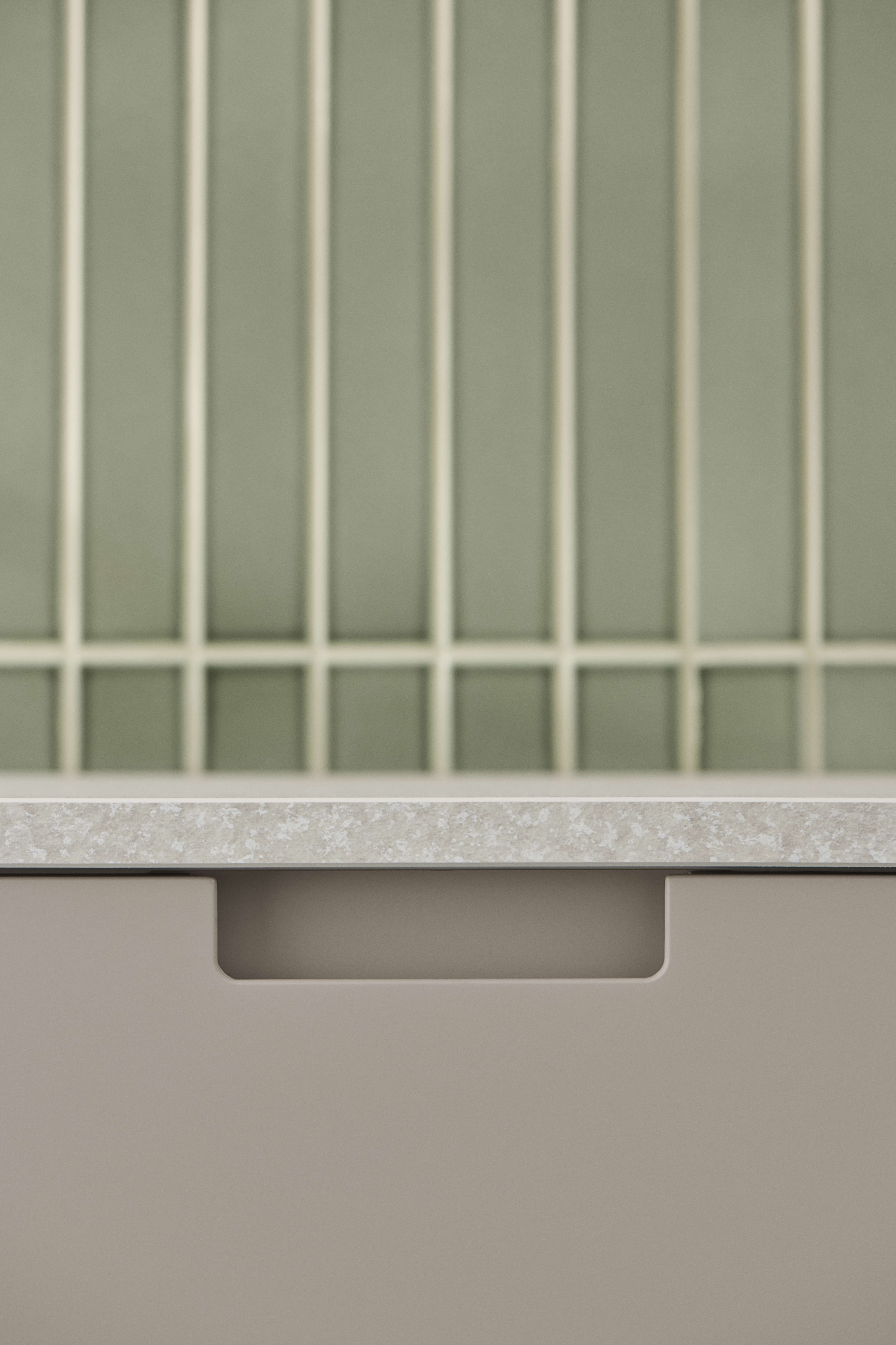 EVENTO arizona beige kitchen drawer with sleek handleless design, featuring a textured countertop above, blending modern style with functionality.