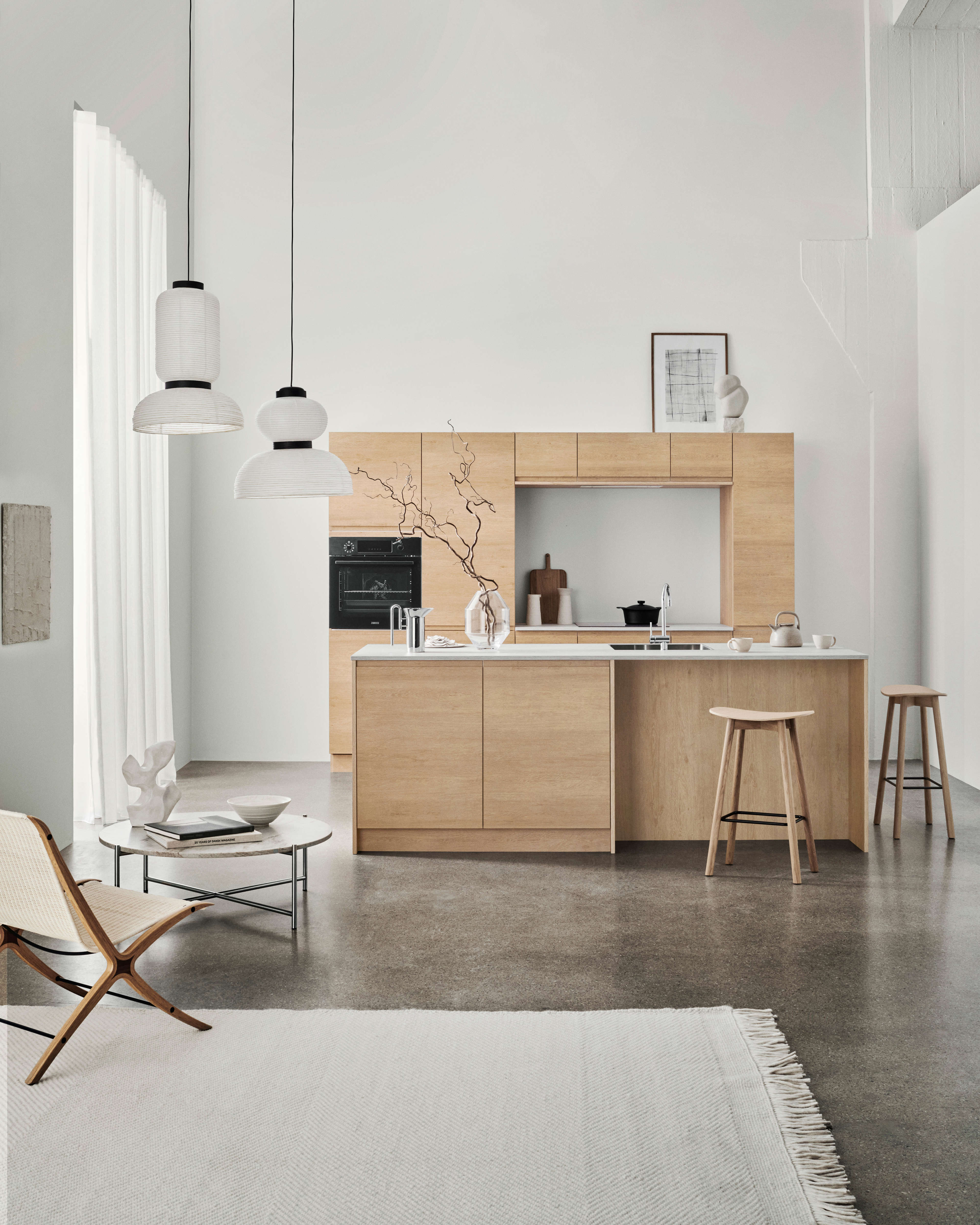 NOLIAM träkök med minimalistisk design och ljus ekfinish, med sömlösa skåp och en elegant ö idealisk för moderna vardagsrum.
