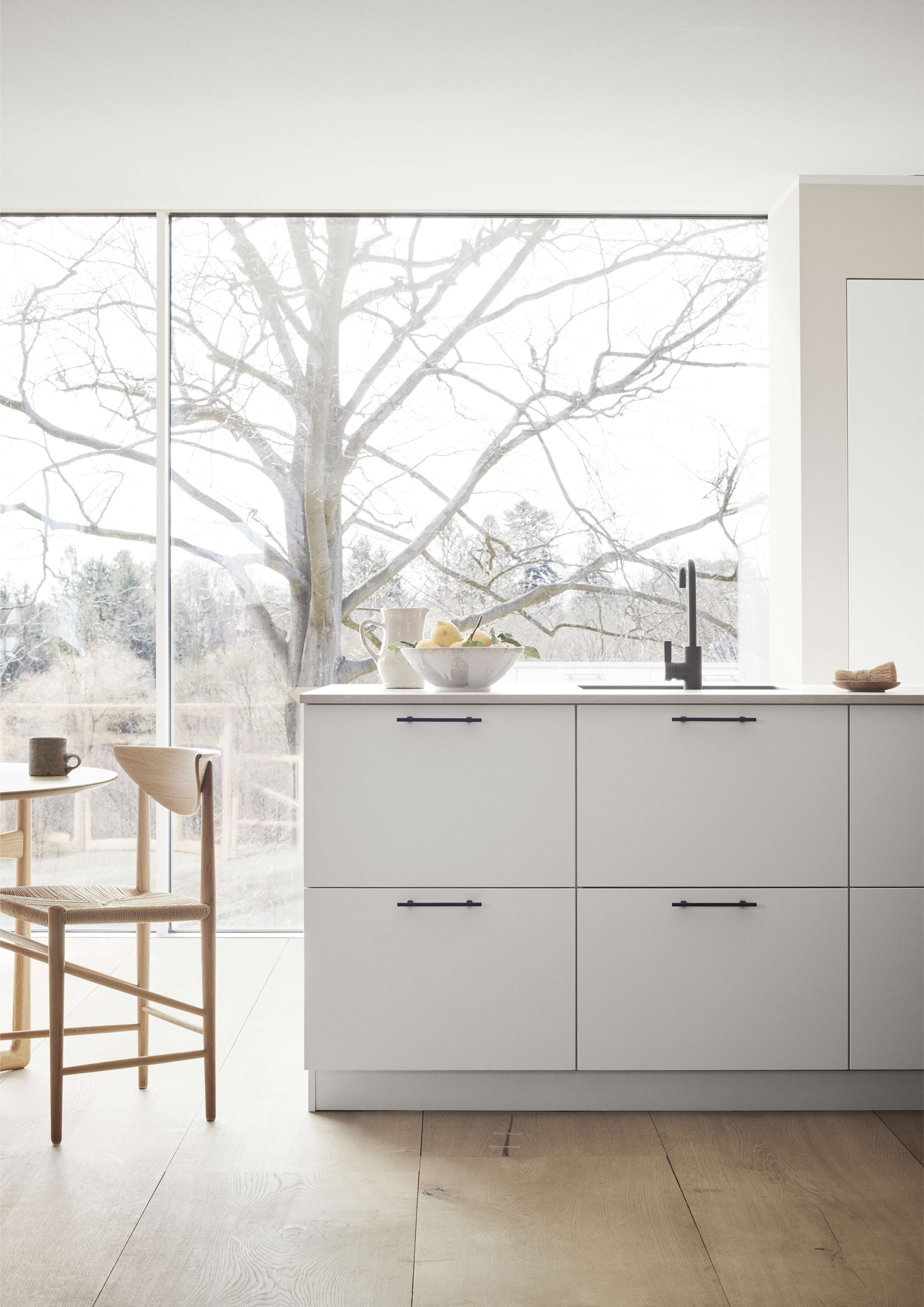 White kitchen with a kitchen island and black handles