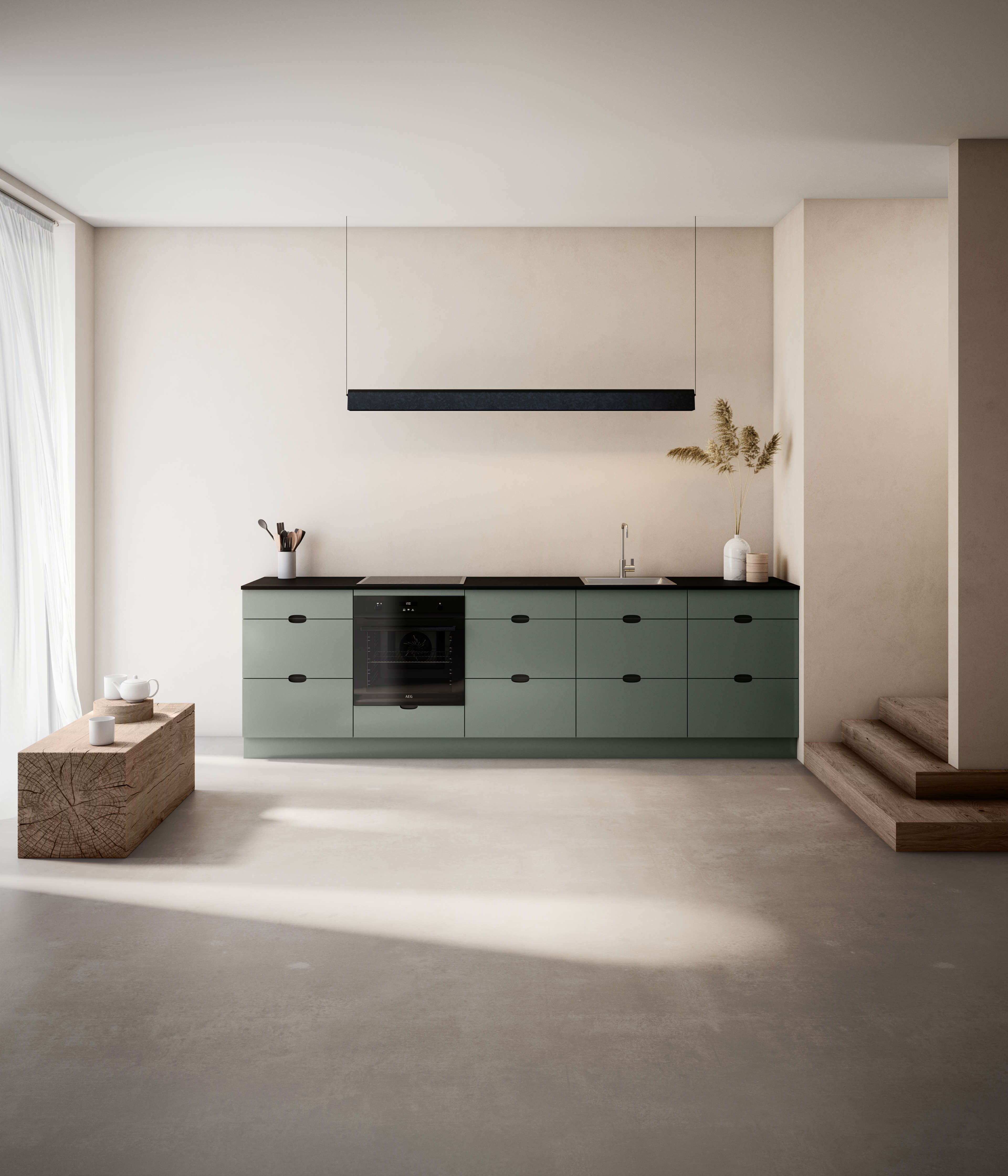 Green kitchen with black handles and an integrated oven