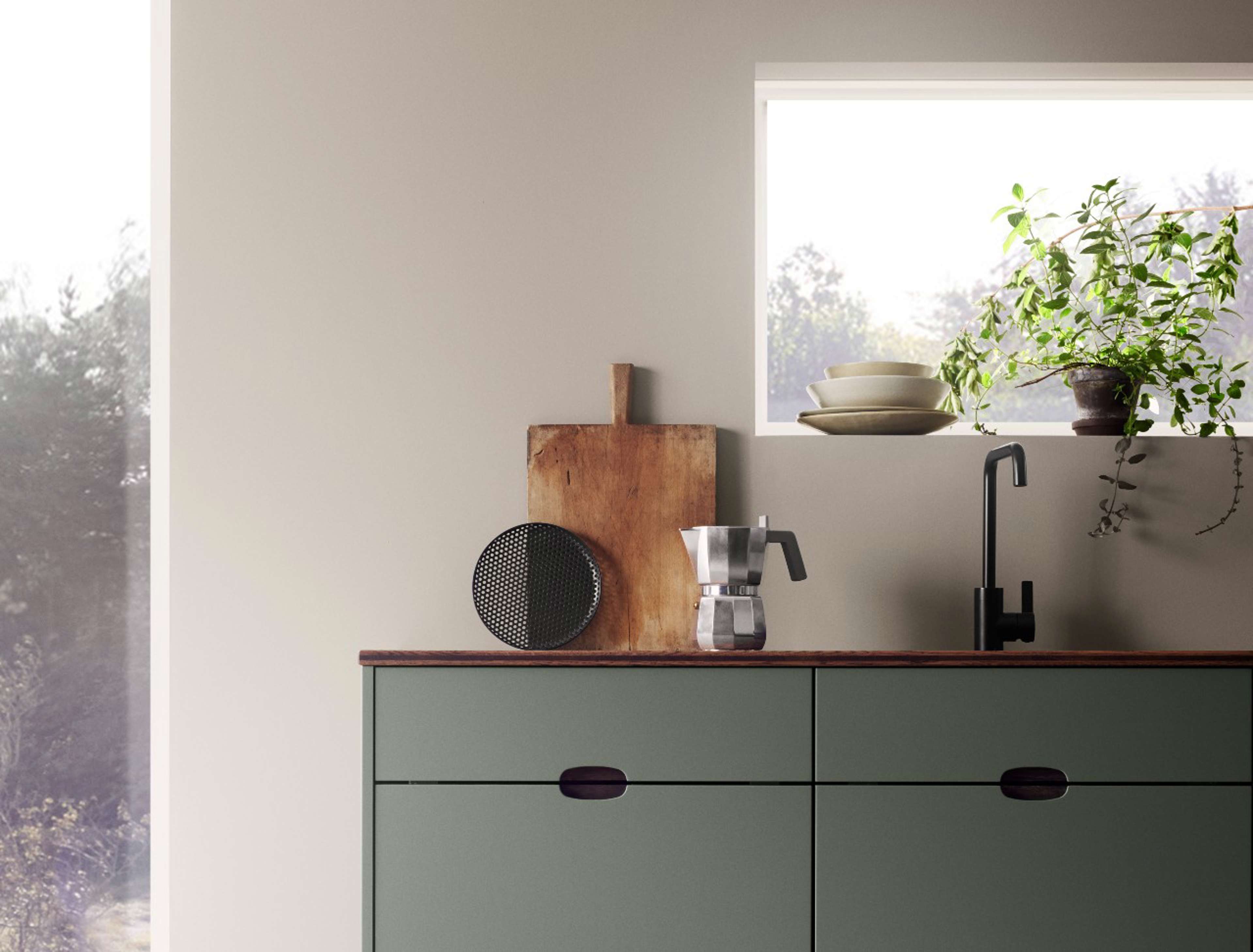 Green kitchen with a wooden worktop and a black faucet